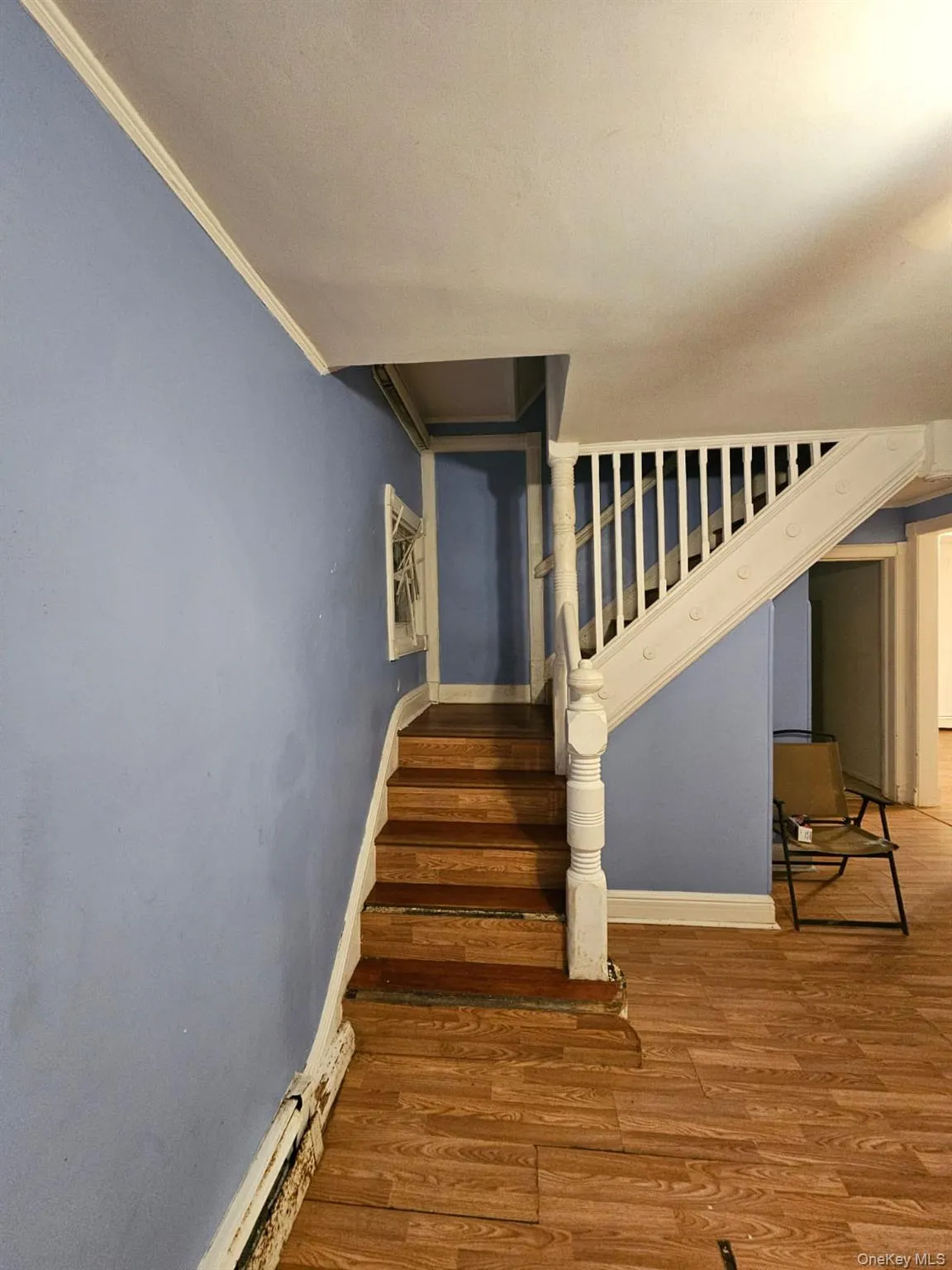 Stairs featuring wood finished floors and ornamental molding Stairs featuring wood finished floors and ornamental molding