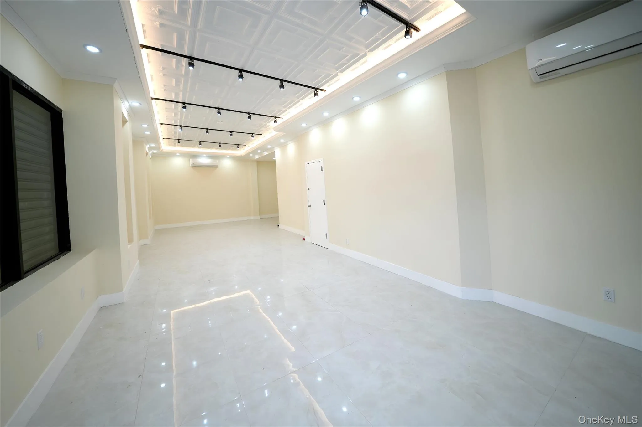 Spare room with track lighting, a wall mounted air conditioner, crown molding, and recessed lighting Spare room with track lighting, a wall mounted air conditioner, crown molding, and recessed lighting