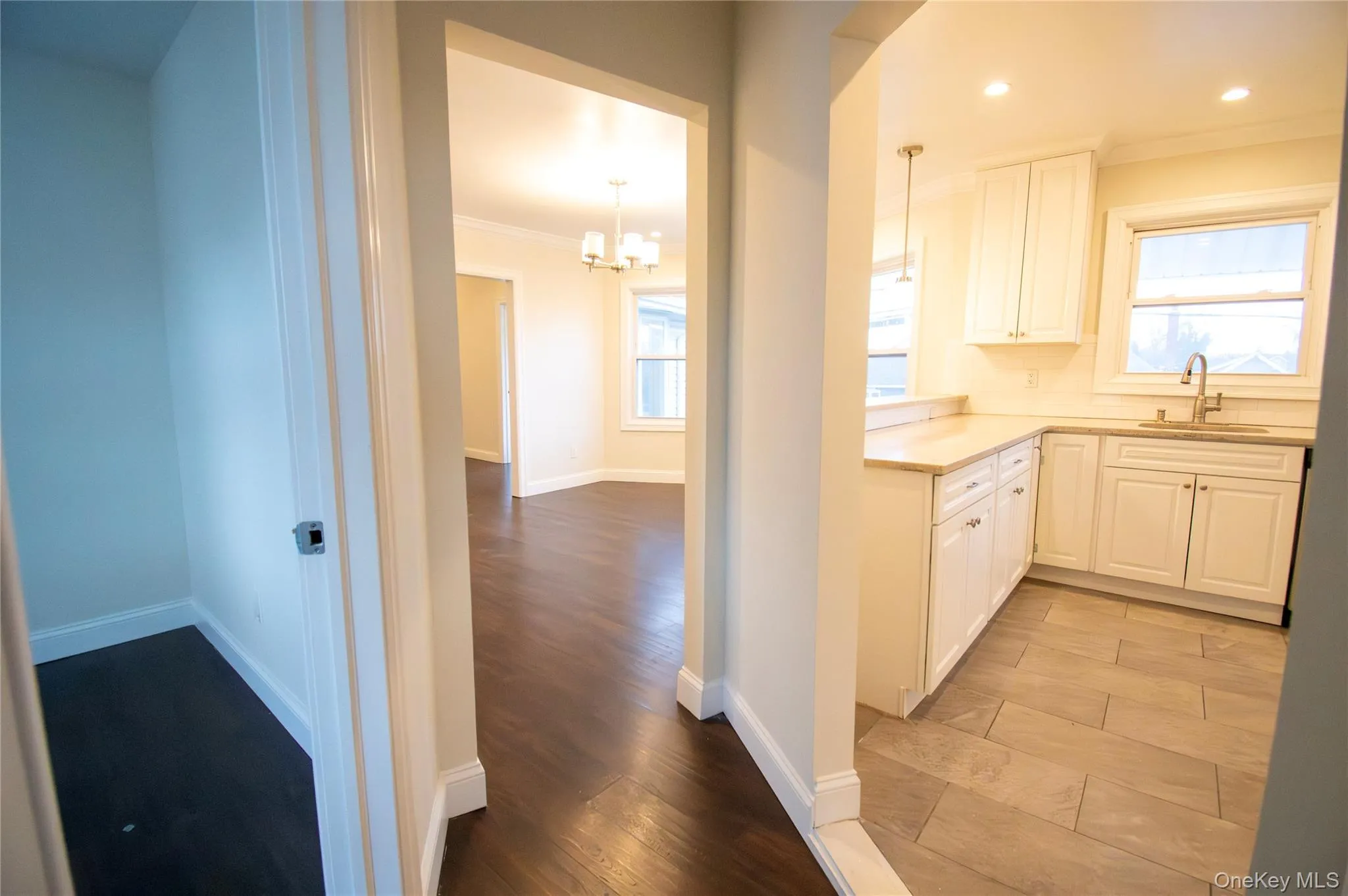 Kitchen with crown molding, white cabinets, healthy amount of natural light, and light wood-style floors Kitchen with crown molding, white cabinets, healthy amount of natural light, and light wood-style floors