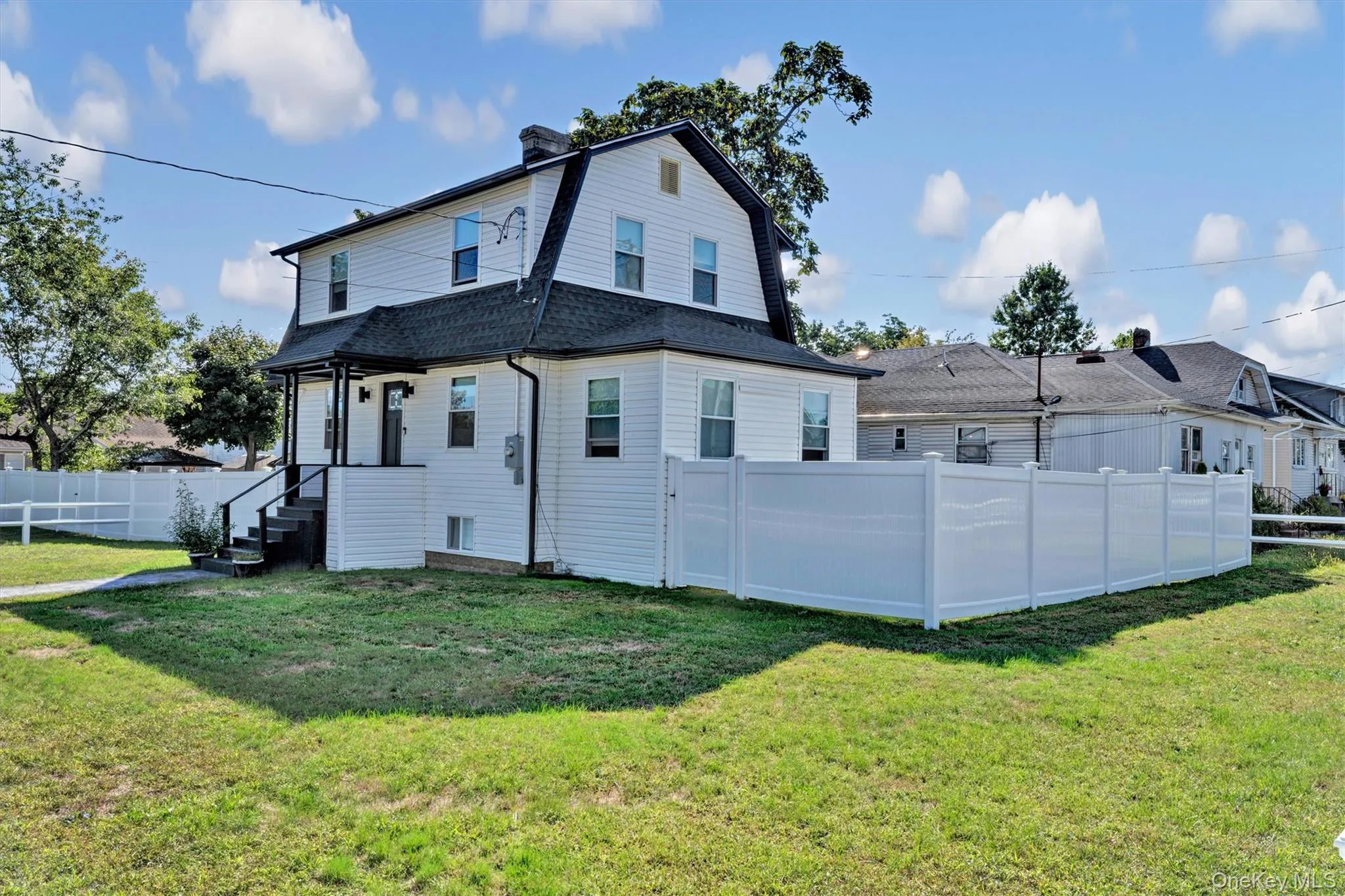 Back of property featuring a gambrel roof, a chimney, and a shingled roof Back of property featuring a gambrel roof, a chimney, and a shingled roof
