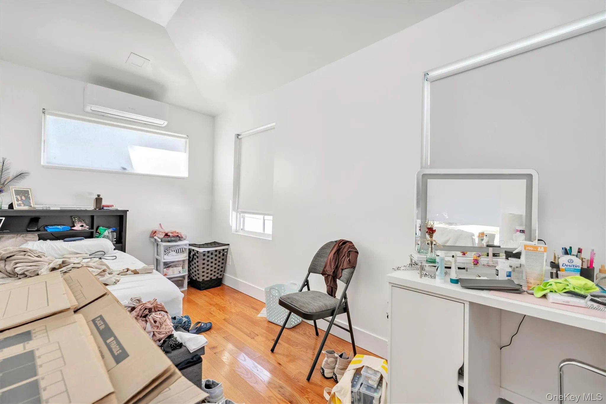 Bedroom featuring light wood-style floors and a wall unit AC Bedroom featuring light wood-style floors and a wall unit AC