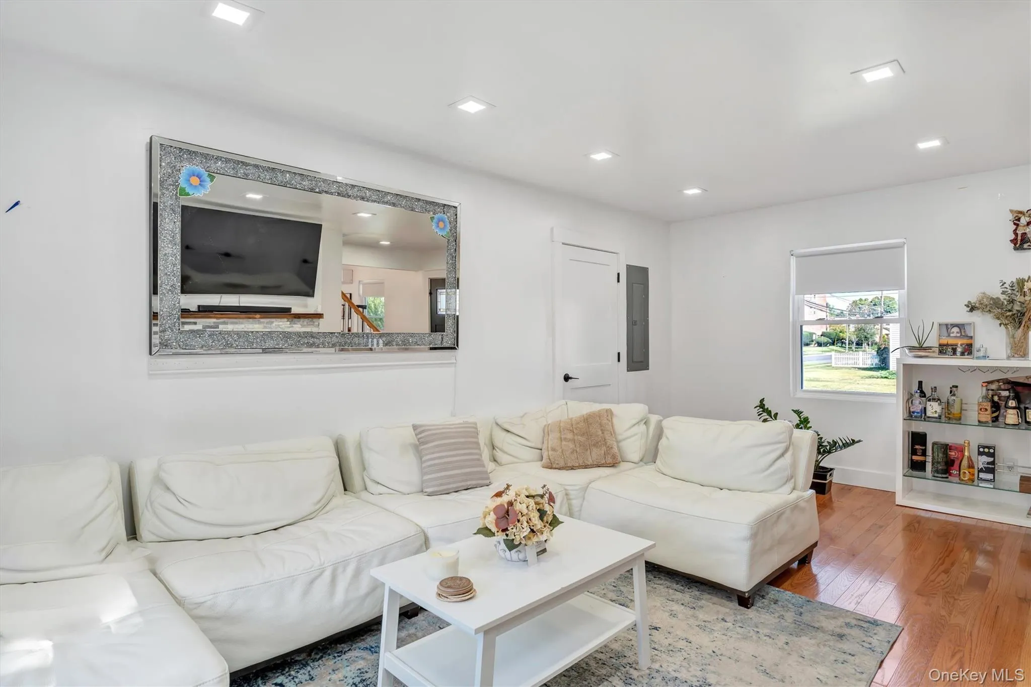 Living area with hardwood / wood-style flooring, recessed lighting, and electric panel Living area with hardwood / wood-style flooring, recessed lighting, and electric panel