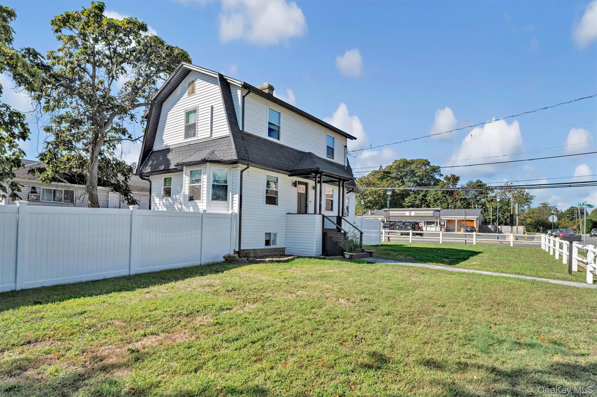View of side of home featuring a gambrel roof, a fenced backyard, a chimney, and roof with shingles View of side of home featuring a gambrel roof, a fenced backyard, a chimney, and roof with shingles