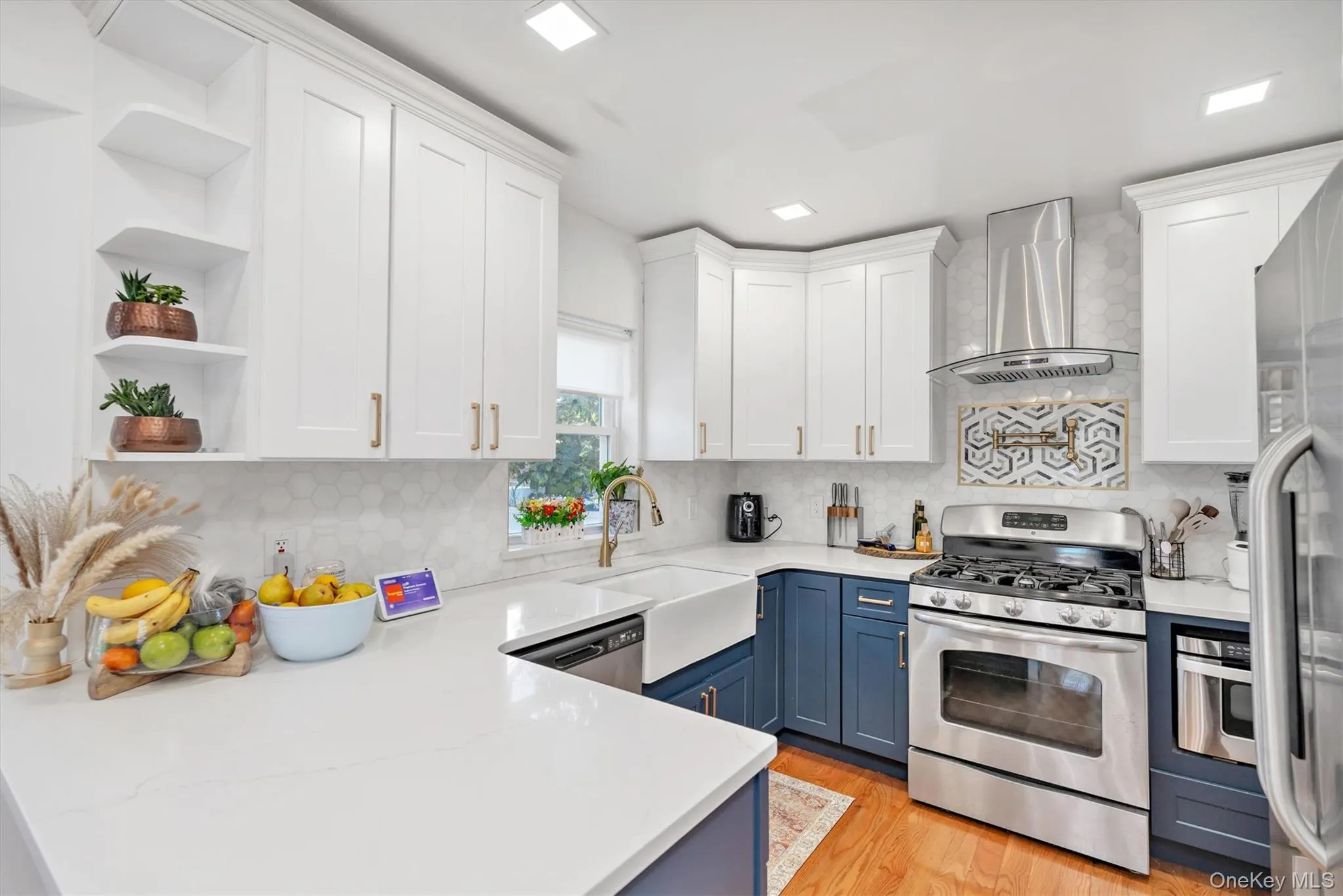 Kitchen with open shelves, white cabinetry, stainless steel appliances, and tasteful backsplash Kitchen with open shelves, white cabinetry, stainless steel appliances, and tasteful backsplash