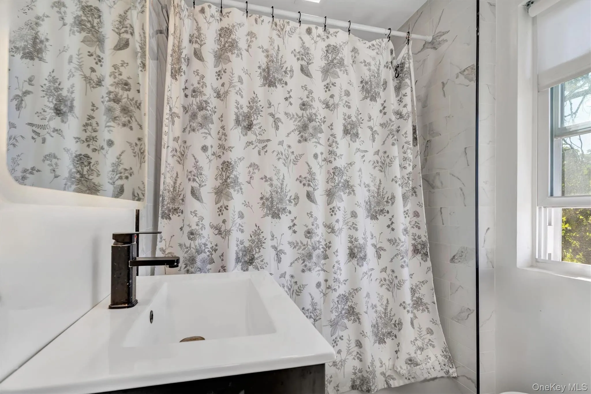 Bathroom with vanity, healthy amount of natural light, and shower / bath combo with shower curtain Bathroom with vanity, healthy amount of natural light, and shower / bath combo with shower curtain