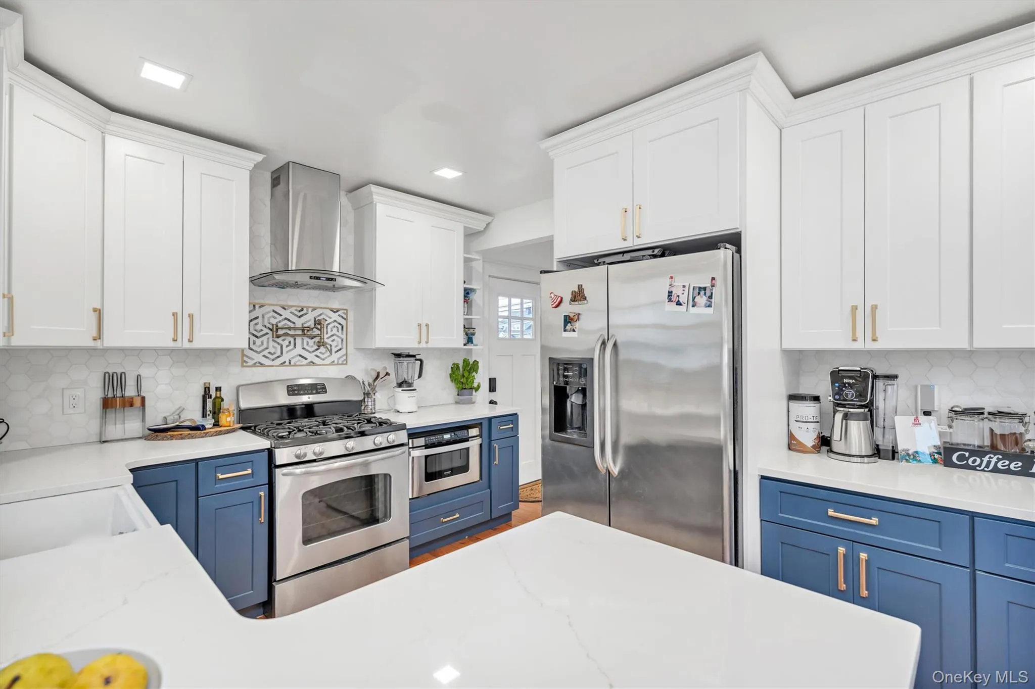Kitchen featuring decorative backsplash, appliances with stainless steel finishes, blue cabinets, and recessed lighting Kitchen featuring decorative backsplash, appliances with stainless steel finishes, blue cabinets, and recessed lighting