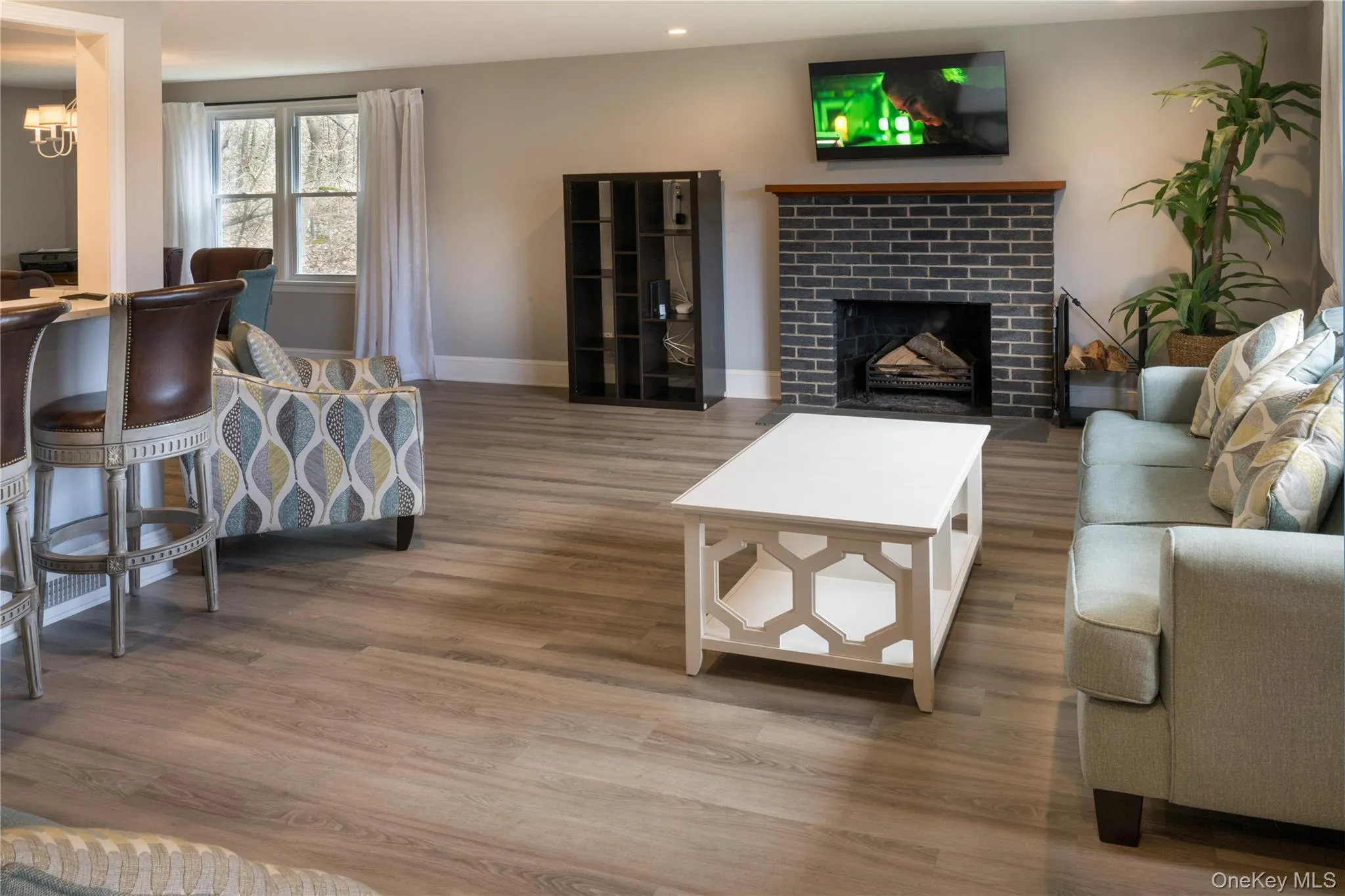 Living area featuring wood finished floors, a fireplace, a chandelier, and recessed lighting Living area featuring wood finished floors, a fireplace, a chandelier, and recessed lighting