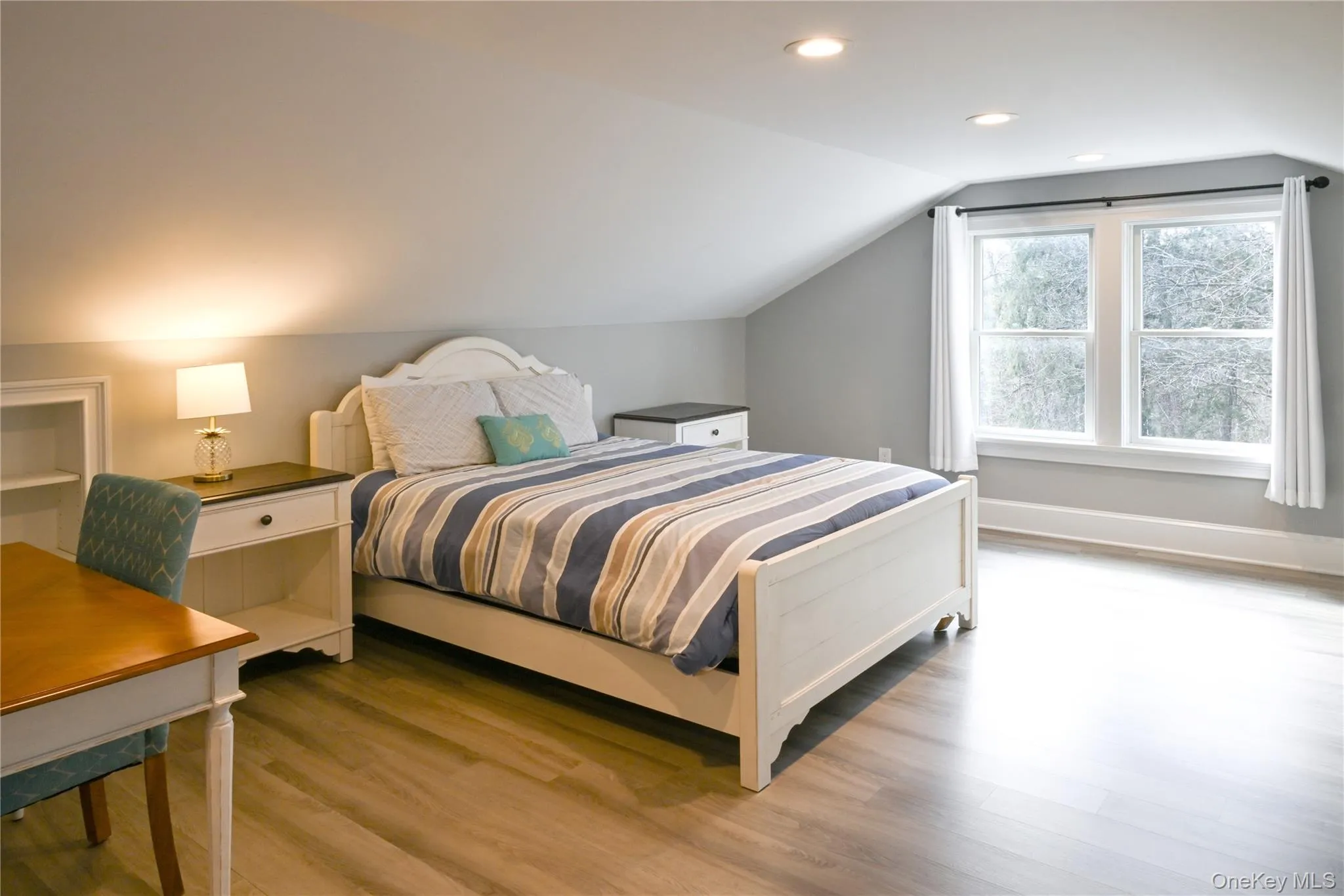 Bedroom featuring lofted ceiling, wood finished floors, and recessed lighting Bedroom featuring lofted ceiling, wood finished floors, and recessed lighting