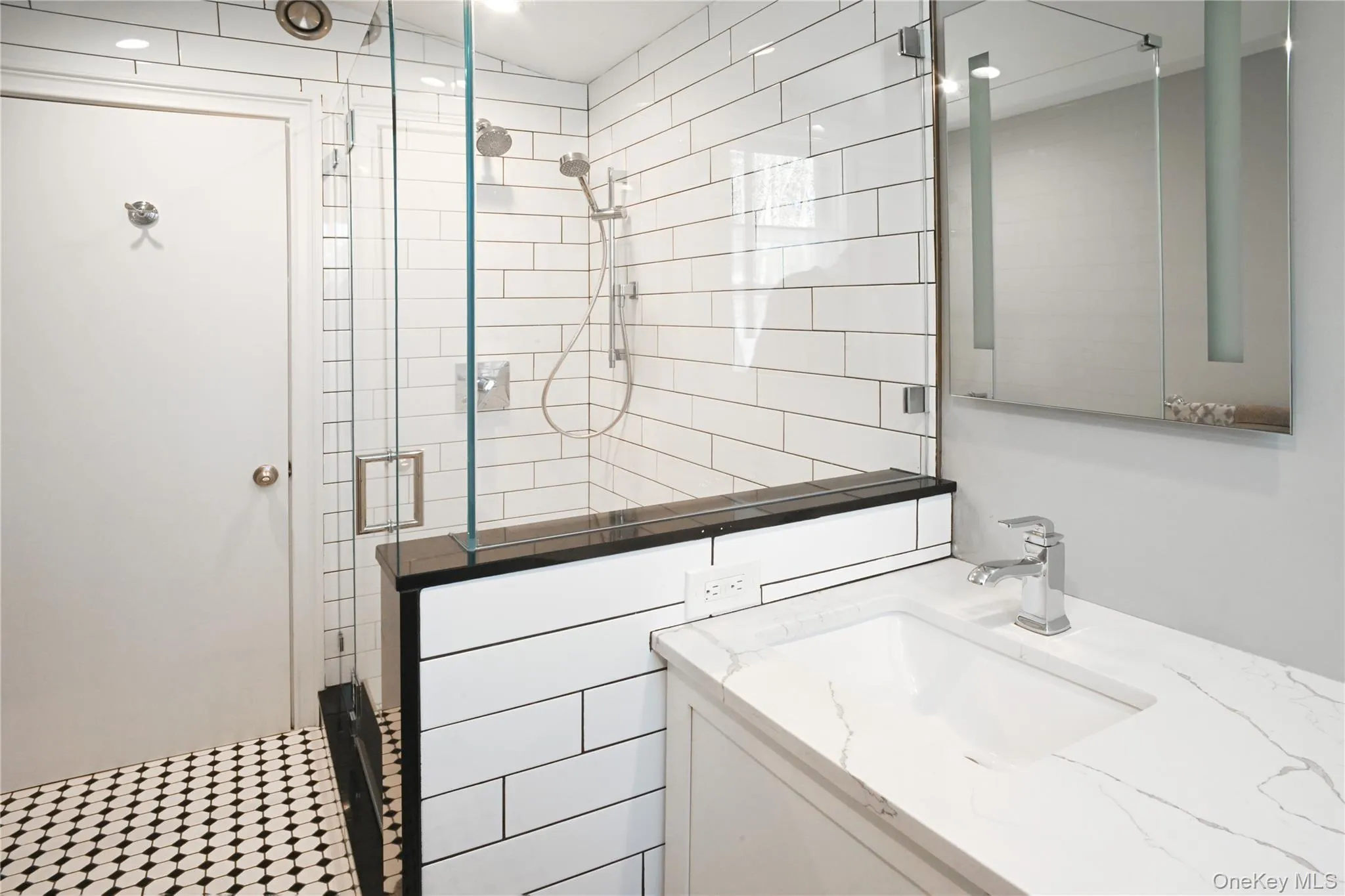 Bathroom featuring a shower stall and vanity Bathroom featuring a shower stall and vanity