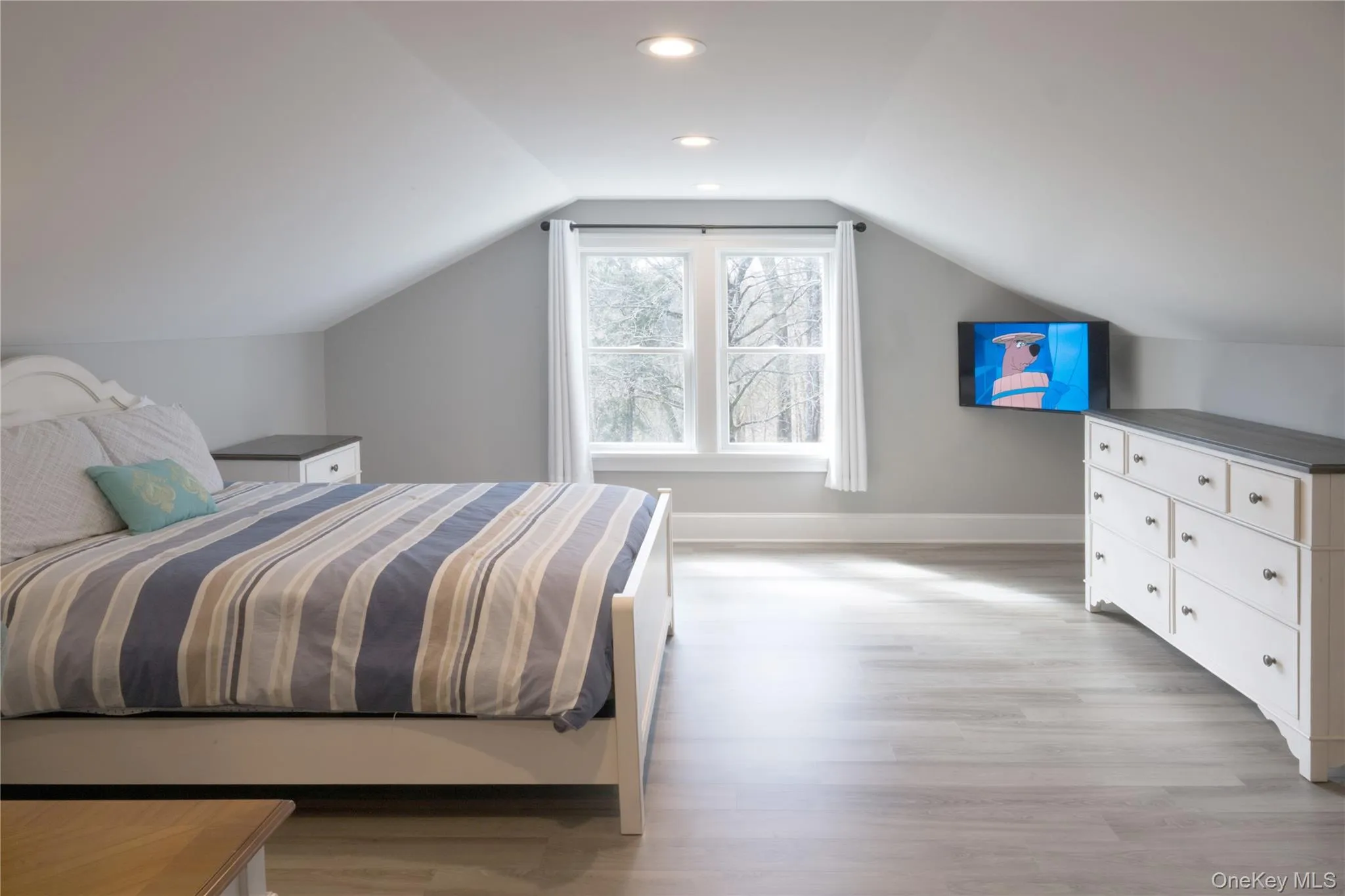 Bedroom with light wood-type flooring and vaulted ceiling Bedroom with light wood-type flooring and vaulted ceiling