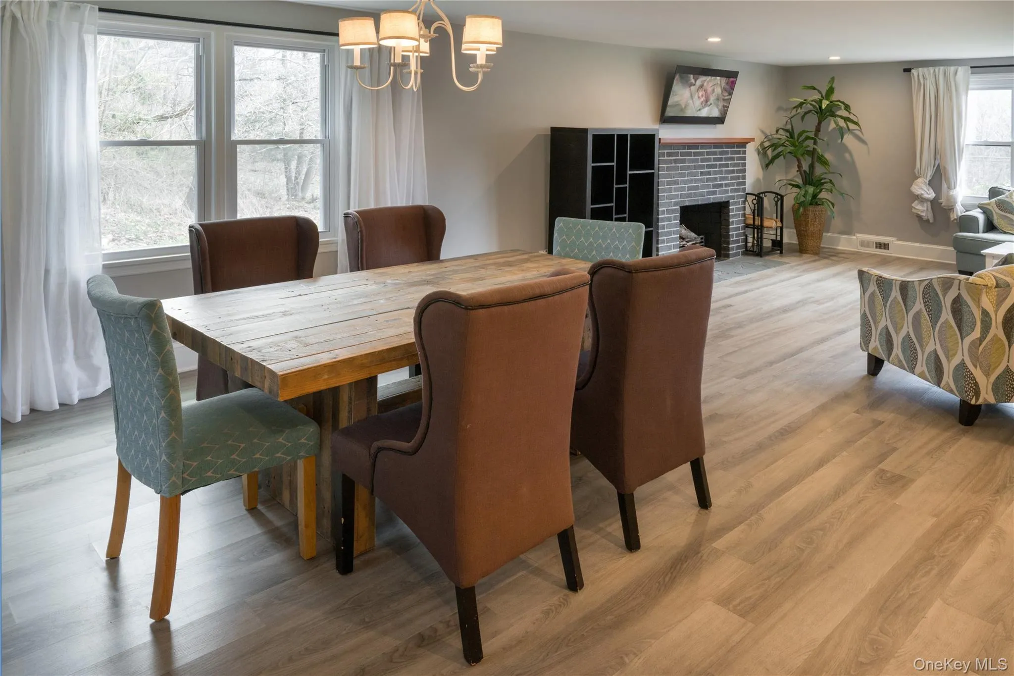 Dining room featuring light wood-type flooring, a fireplace, a chandelier, and recessed lighting Dining room featuring light wood-type flooring, a fireplace, a chandelier, and recessed lighting