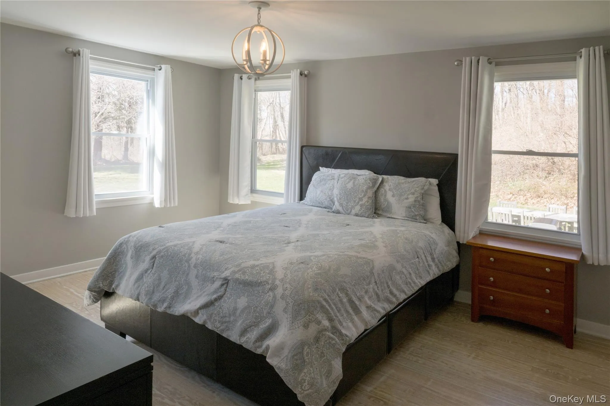 Bedroom featuring light wood-style flooring and a chandelier Bedroom featuring light wood-style flooring and a chandelier