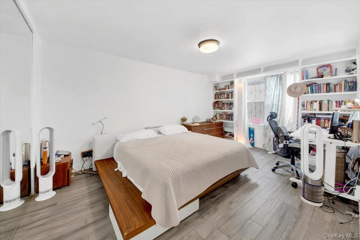 Bedroom with an office area and wood finished floors Bedroom with an office area and wood finished floors