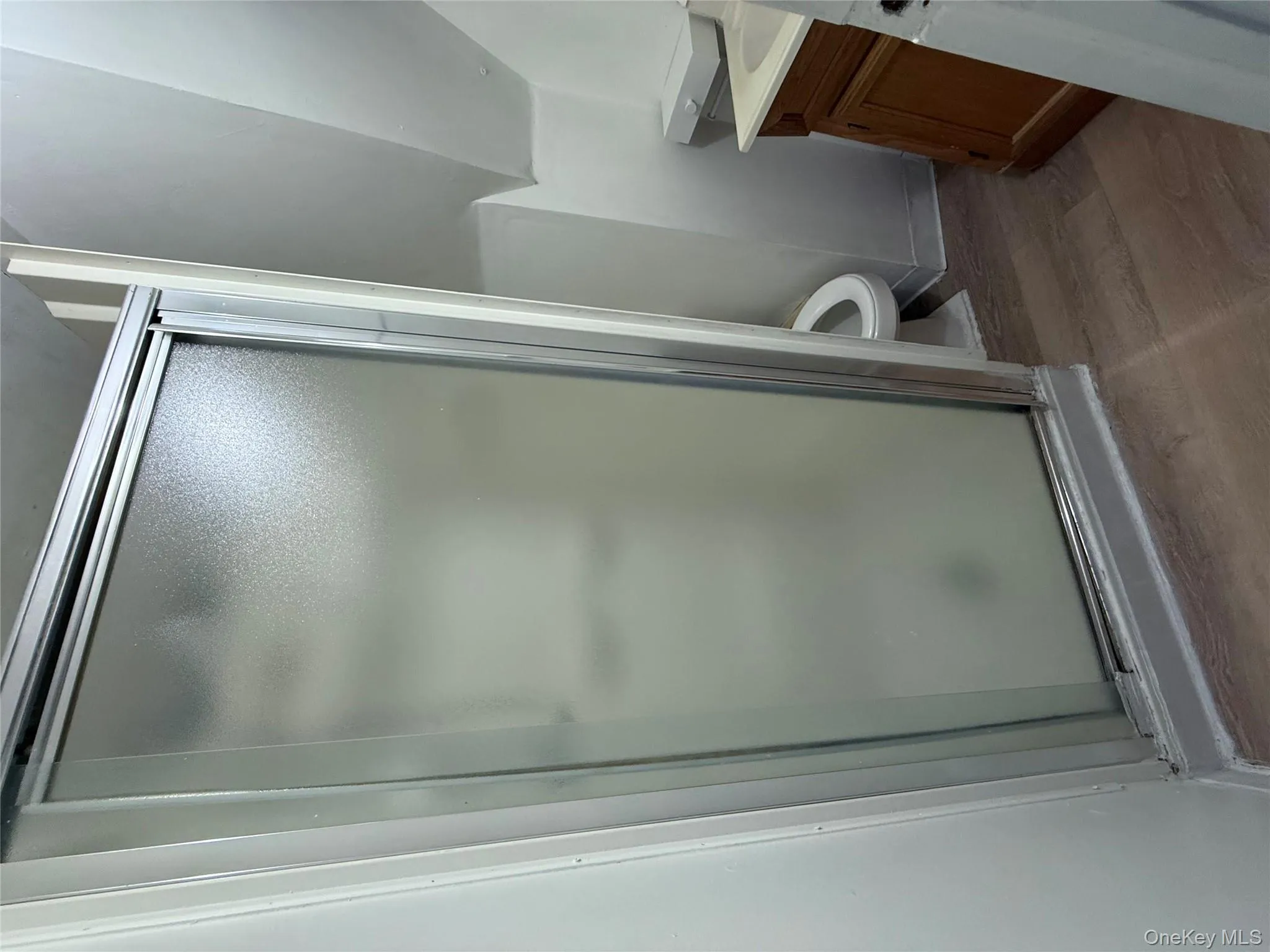 Full bath with vanity, dark wood-style floors, and a shower stall Full bath with vanity, dark wood-style floors, and a shower stall