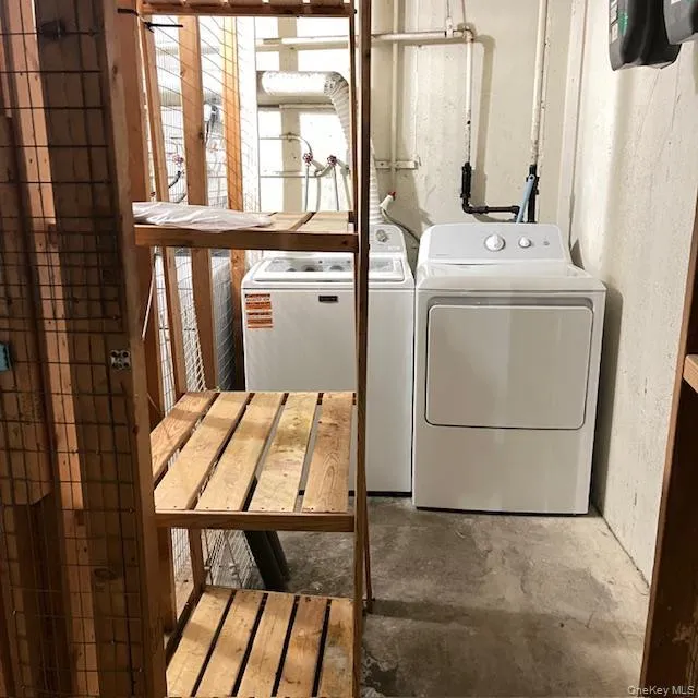 Washroom featuring concrete flooring and washing machine and dryer Washroom featuring concrete flooring and washing machine and dryer