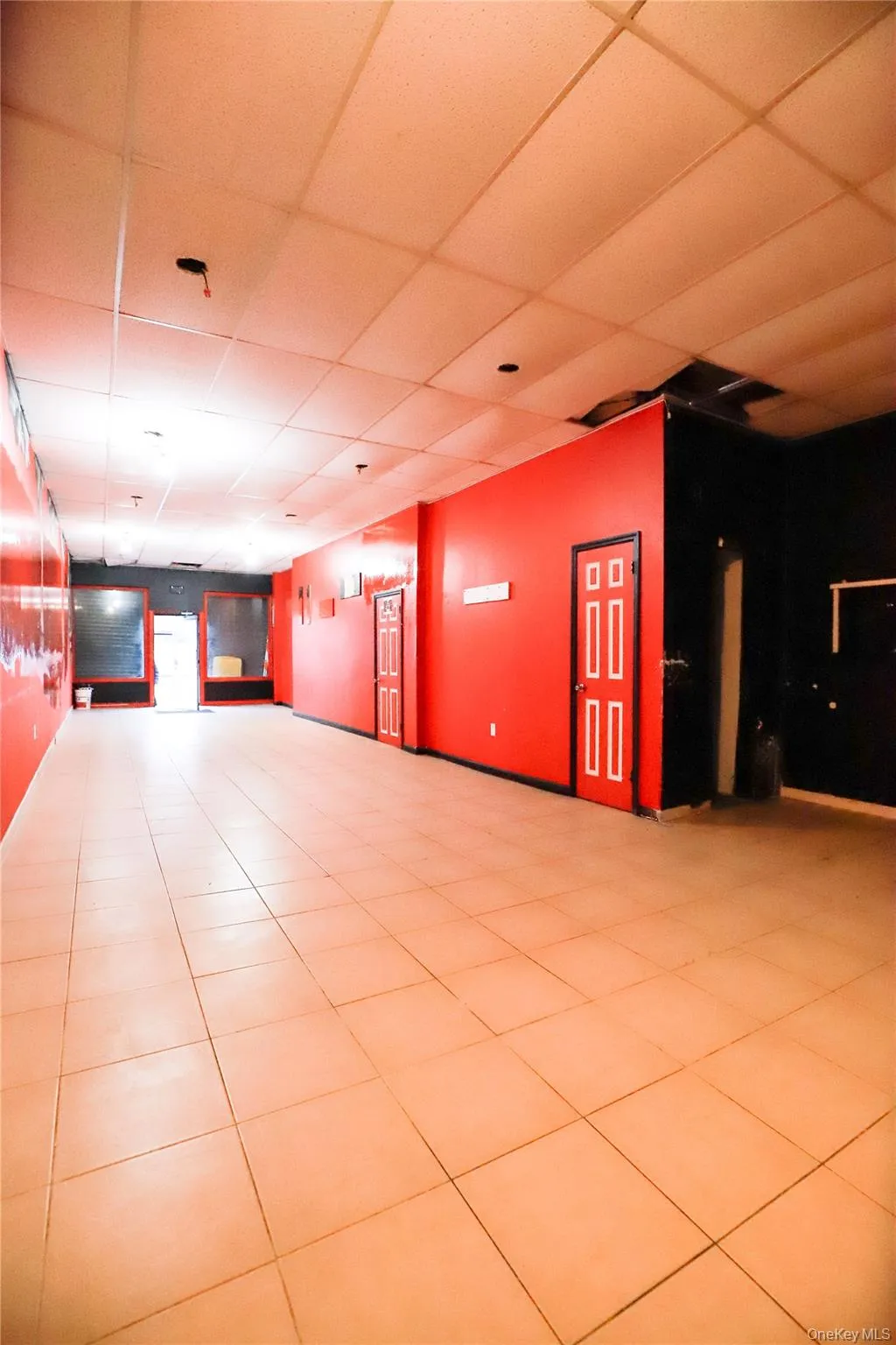 Empty room with a paneled ceiling and tile patterned flooring Empty room with a paneled ceiling and tile patterned flooring