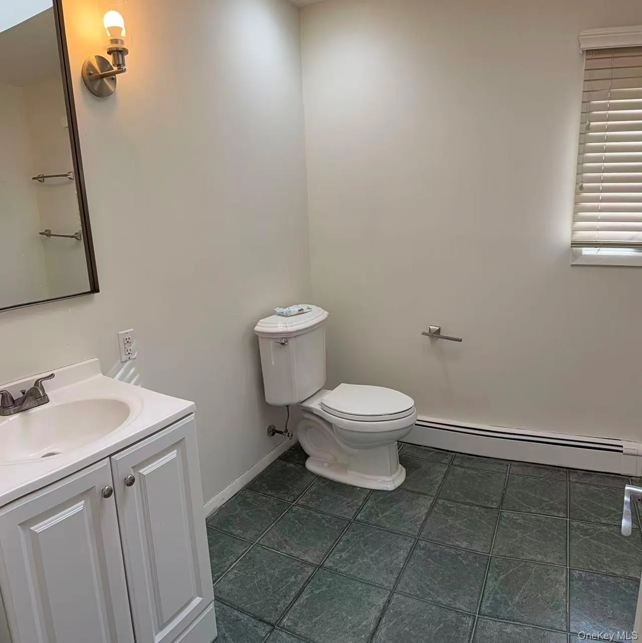 Half bathroom with a baseboard radiator and vanity Half bathroom with a baseboard radiator and vanity