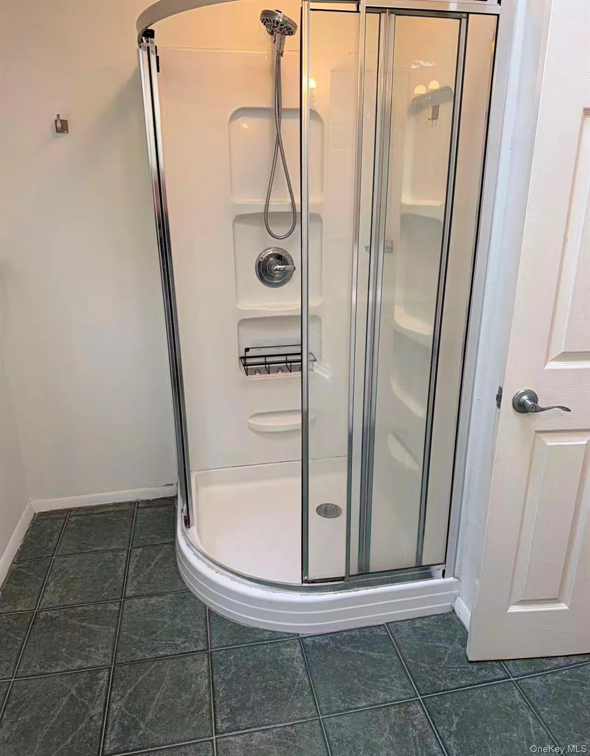 Full bathroom with a stall shower and dark tile patterned floors Full bathroom with a stall shower and dark tile patterned floors