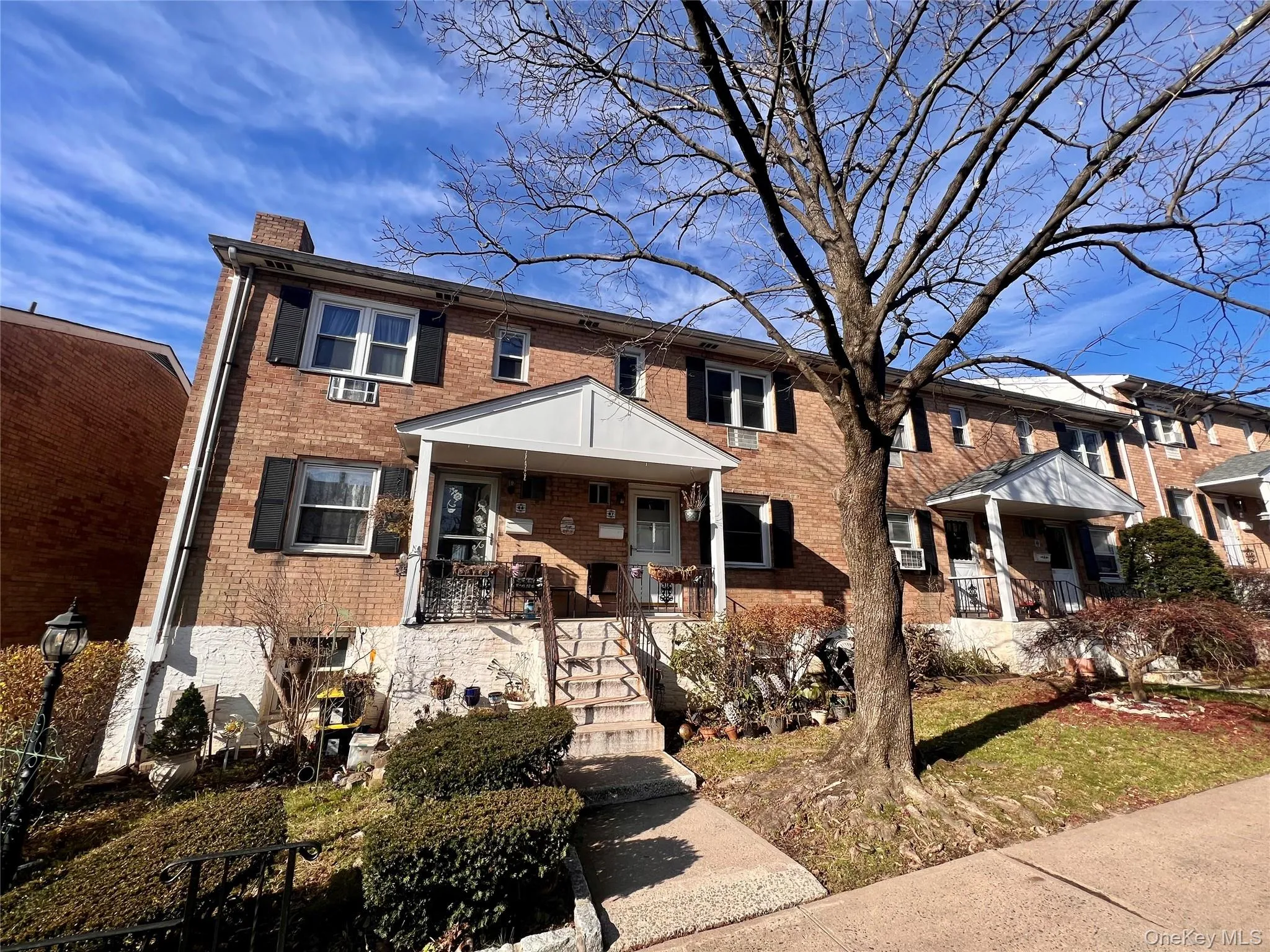 View of front of home featuring brick siding, a chimney, and a porch View of front of home featuring brick siding, a chimney, and a porch