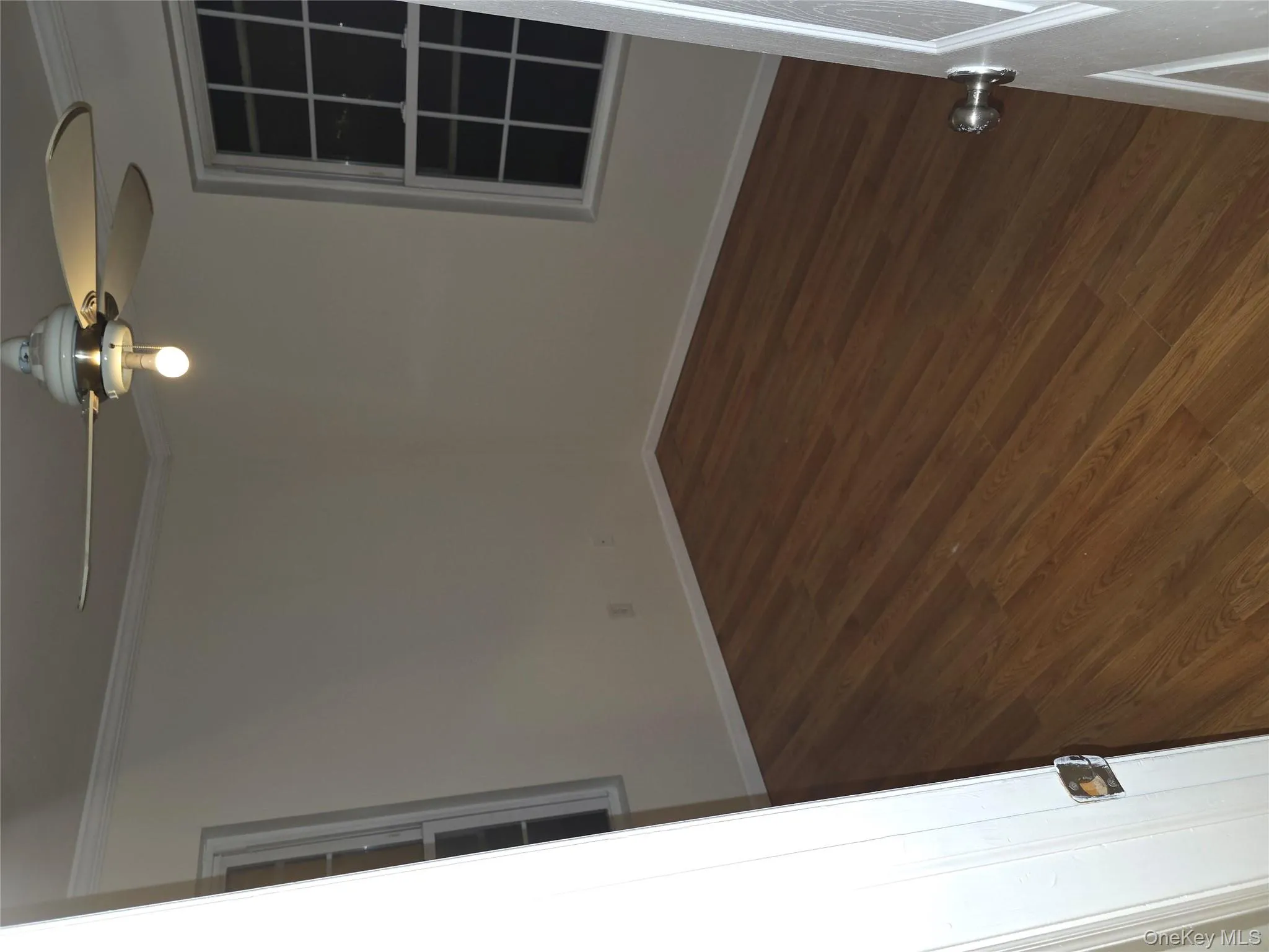 Spare room featuring dark wood-style flooring, crown molding, and a ceiling fan Spare room featuring dark wood-style flooring, crown molding, and a ceiling fan