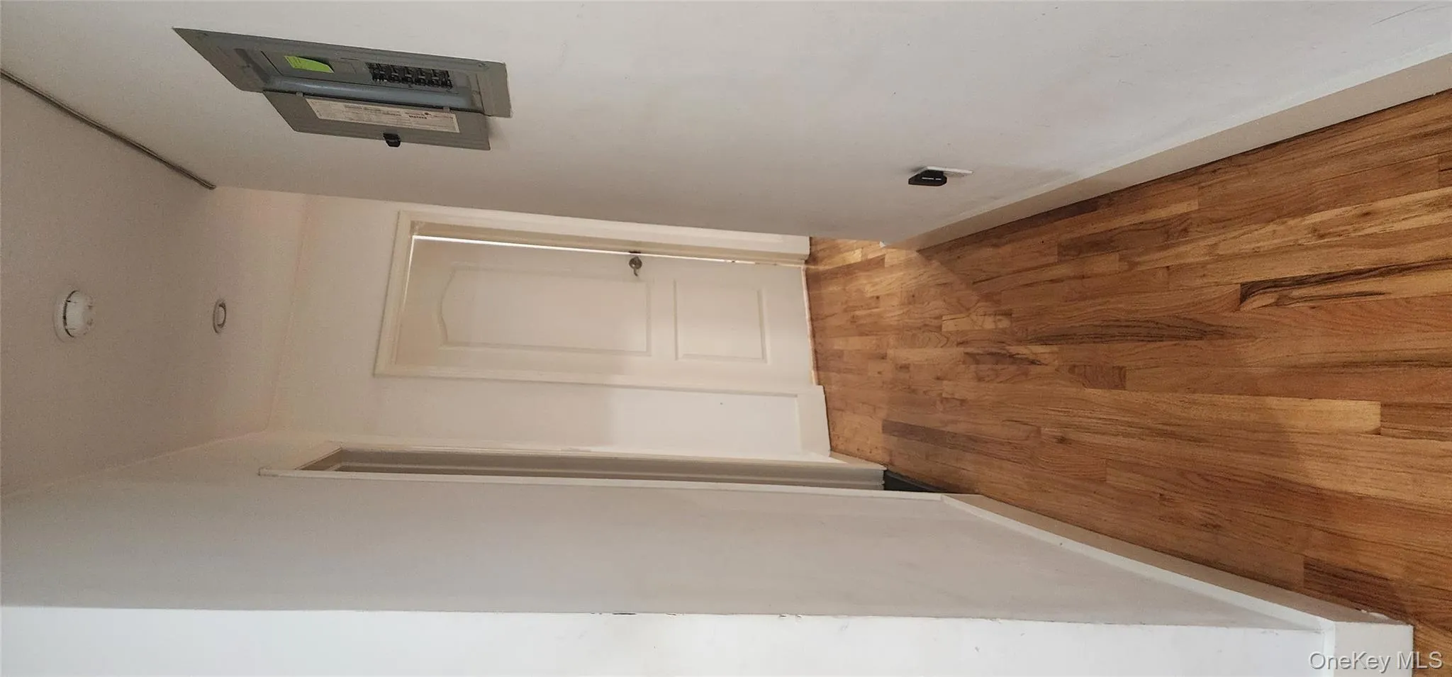 Hall with light wood-type flooring and electric panel Hall with light wood-type flooring and electric panel