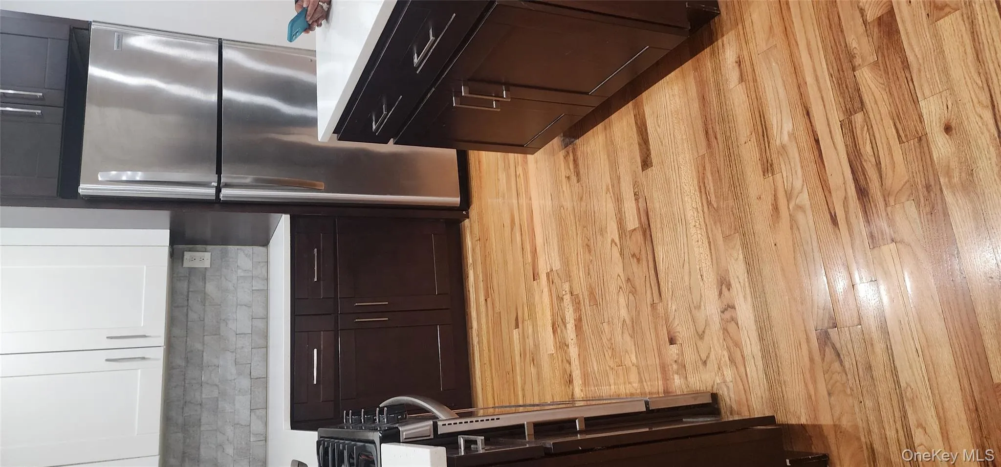 Kitchen with refrigerator, stainless steel range oven, dark brown cabinets, white cabinets, and backsplash Kitchen with refrigerator, stainless steel range oven, dark brown cabinets, white cabinets, and backsplash