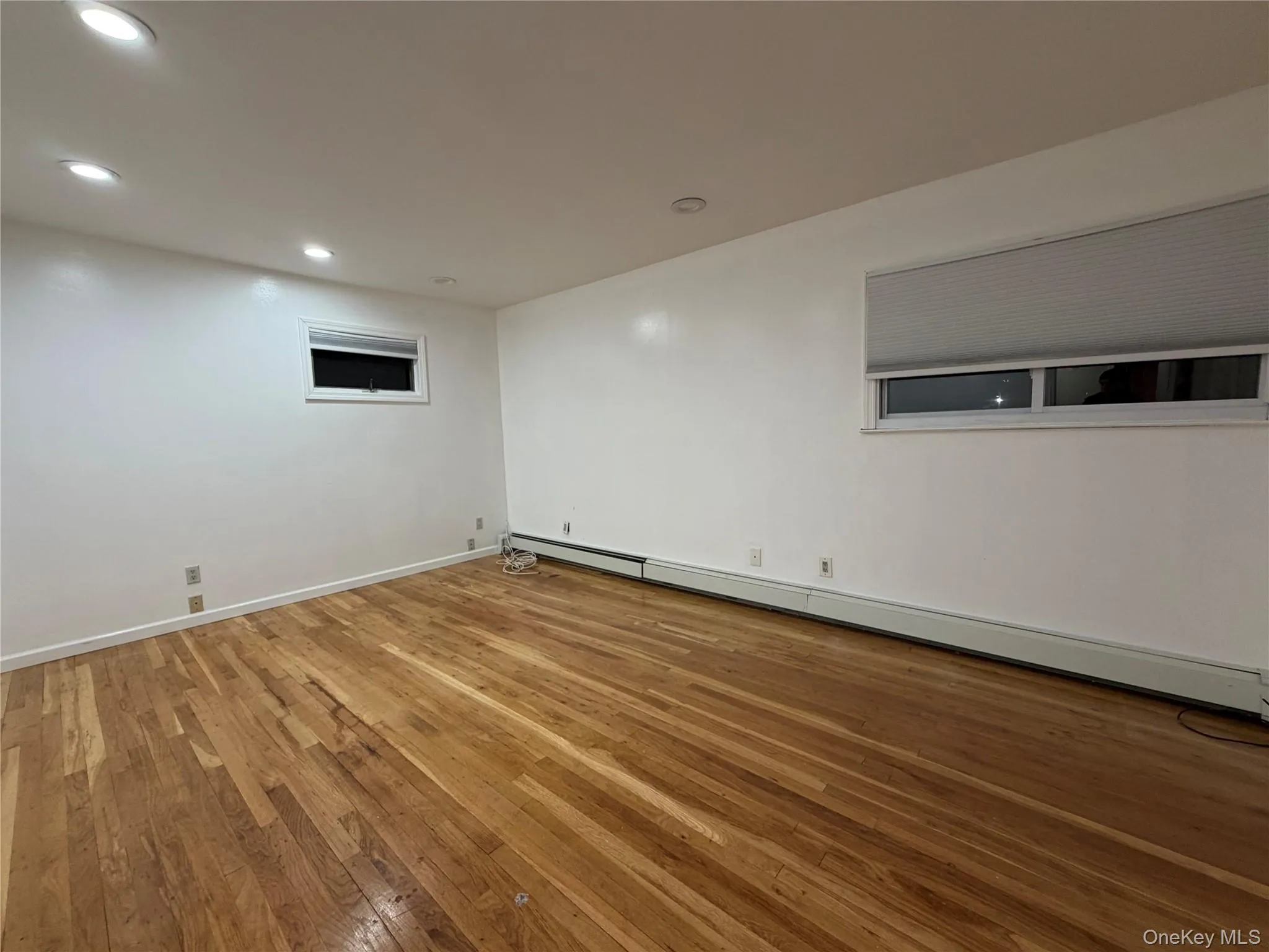 Spare room featuring a baseboard radiator, light wood-style floors, and recessed lighting Spare room featuring a baseboard radiator, light wood-style floors, and recessed lighting