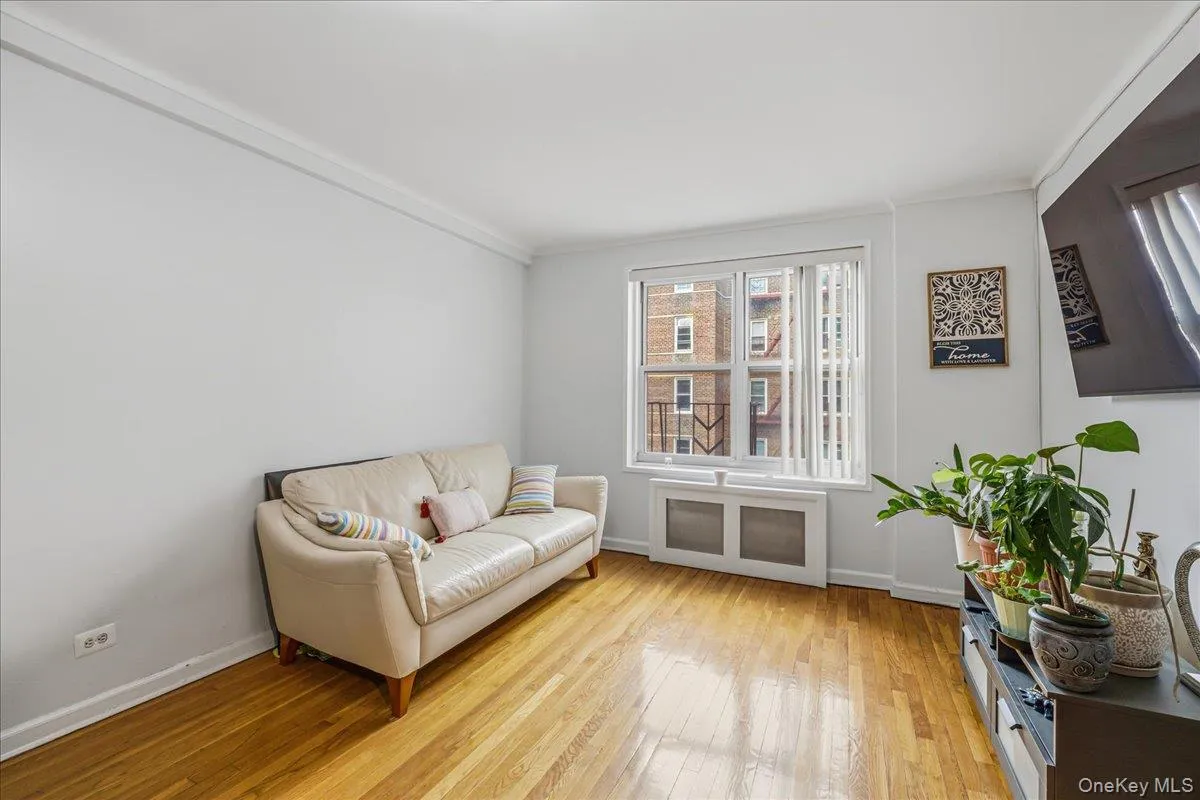 Sitting room featuring radiator heating unit, light wood-style flooring, and crown molding Sitting room featuring radiator heating unit, light wood-style flooring, and crown molding