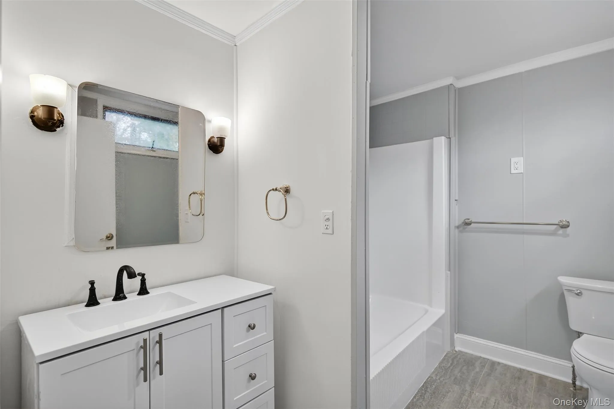 Bathroom with vanity, crown molding, and shower / bathtub combination Bathroom with vanity, crown molding, and shower / bathtub combination