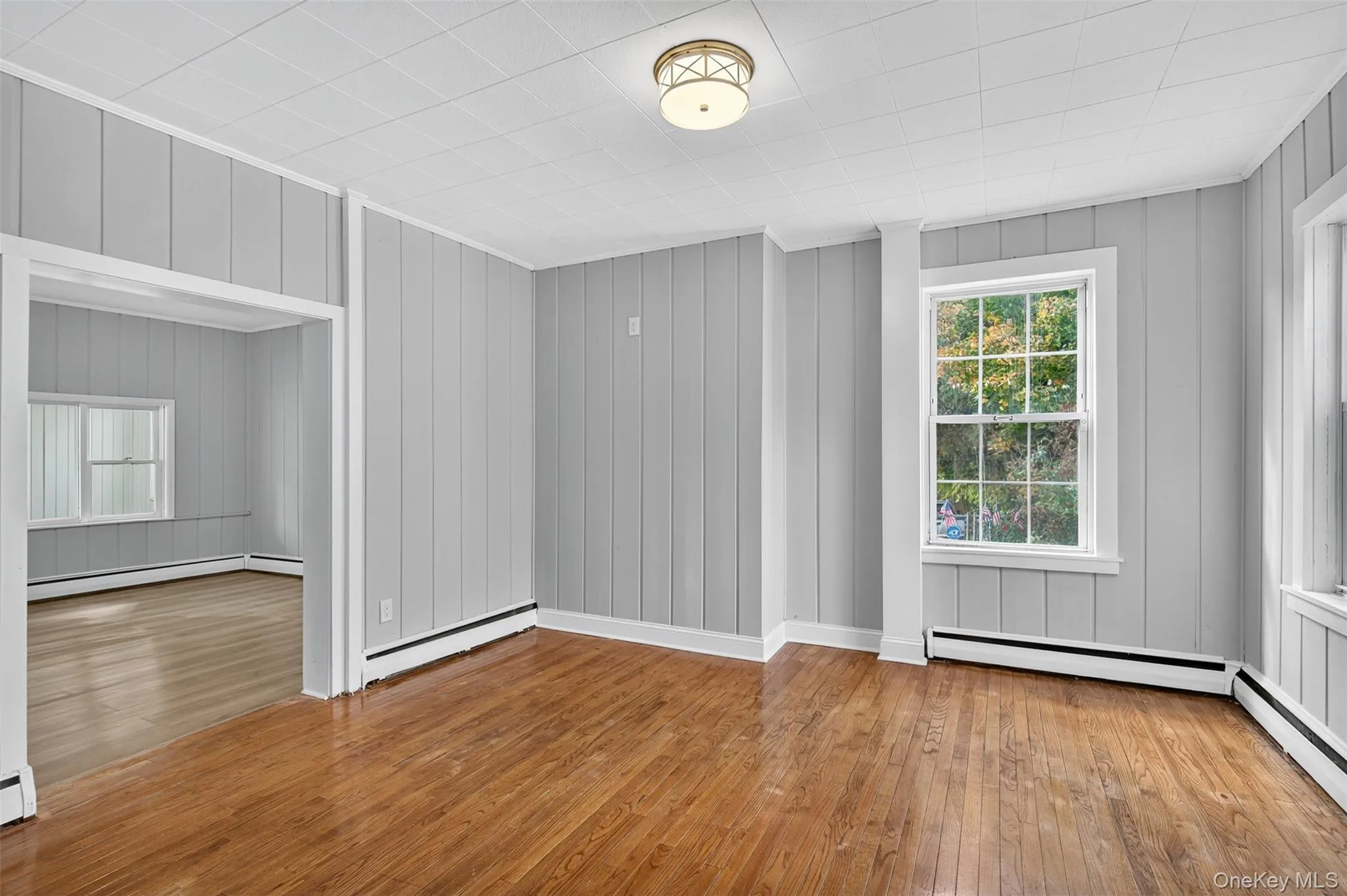 Spare room with hardwood / wood-style flooring, a baseboard heating unit, and baseboard heating Spare room with hardwood / wood-style flooring, a baseboard heating unit, and baseboard heating