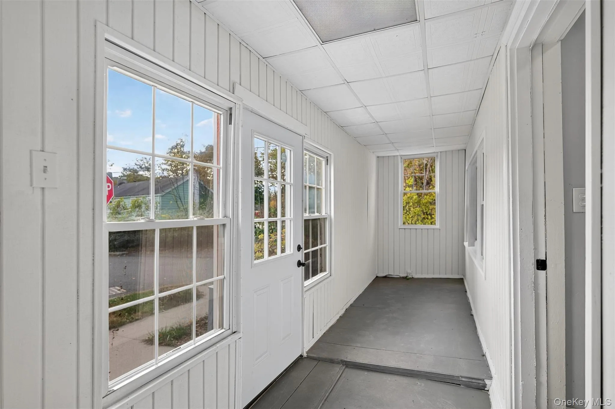 Unfurnished sunroom featuring concrete floors Unfurnished sunroom featuring concrete floors