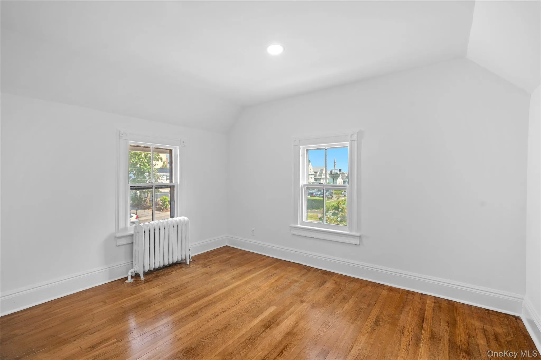 Bonus room featuring lofted ceiling, radiator, healthy amount of natural light, and hardwood / wood-style flooring Bonus room featuring lofted ceiling, radiator, healthy amount of natural light, and hardwood / wood-style flooring