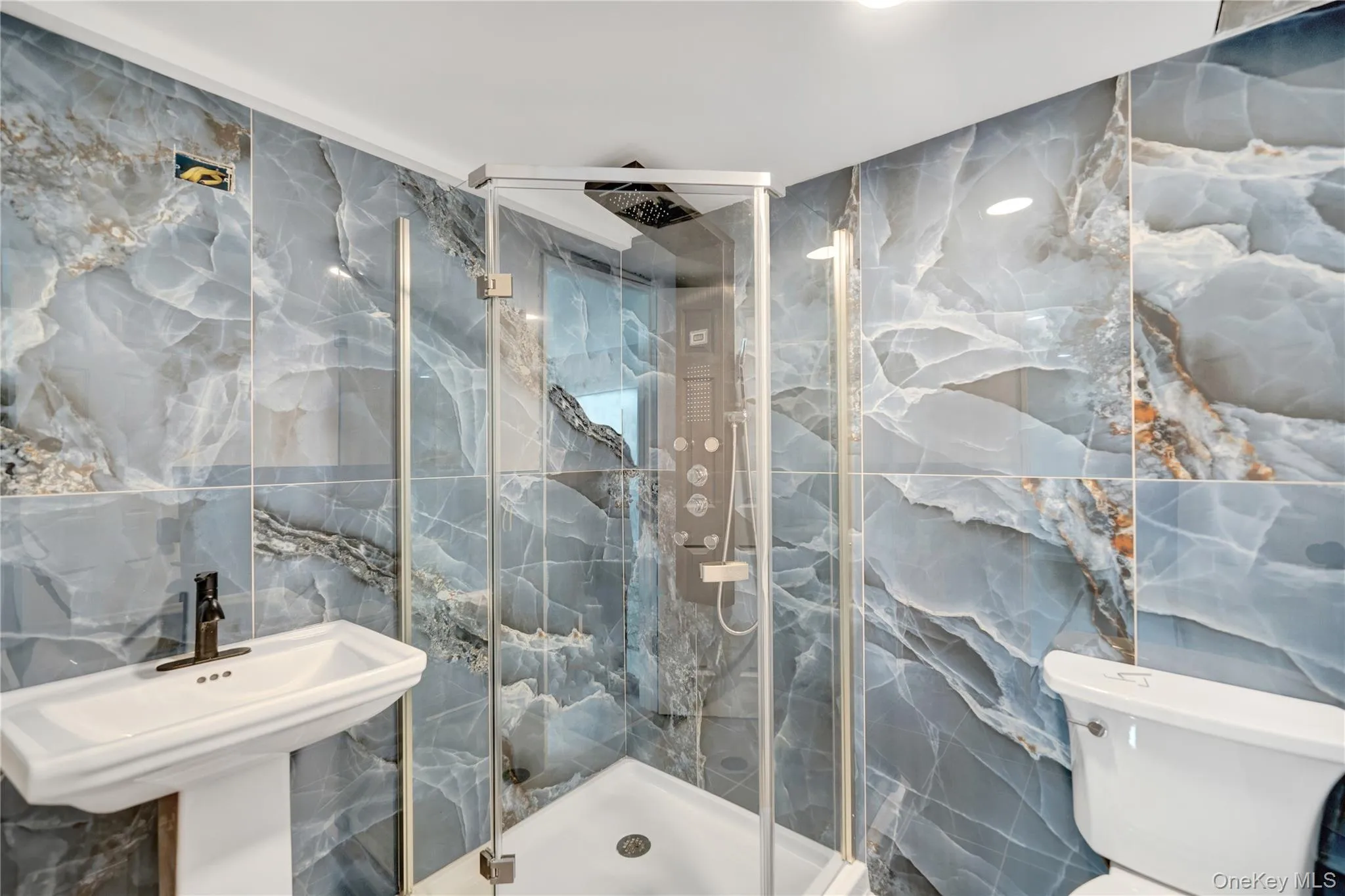 Bathroom with tile walls, a marble finish shower, and stone wall Bathroom with tile walls, a marble finish shower, and stone wall