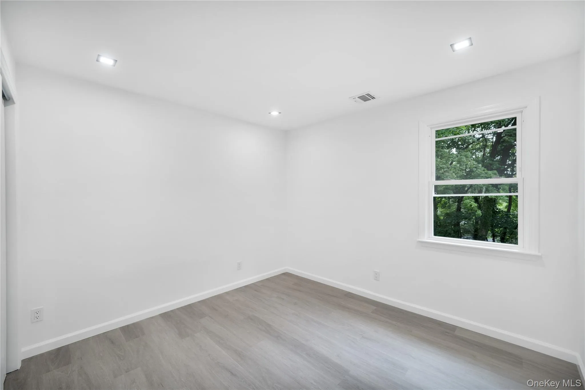 Empty room with baseboards and light wood-type flooring Empty room with baseboards and light wood-type flooring