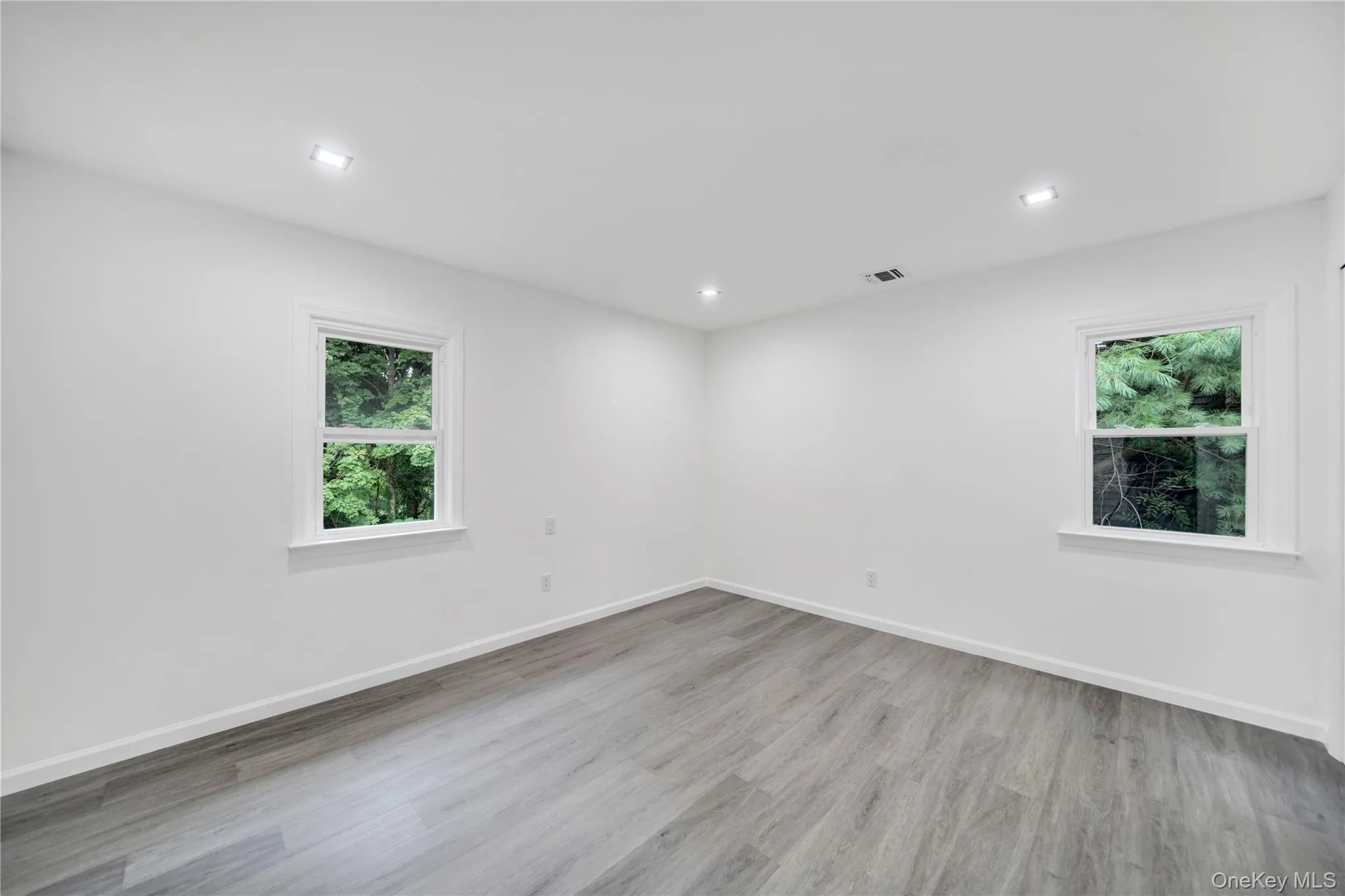 Empty room with light wood finished floors and recessed lighting Empty room with light wood finished floors and recessed lighting