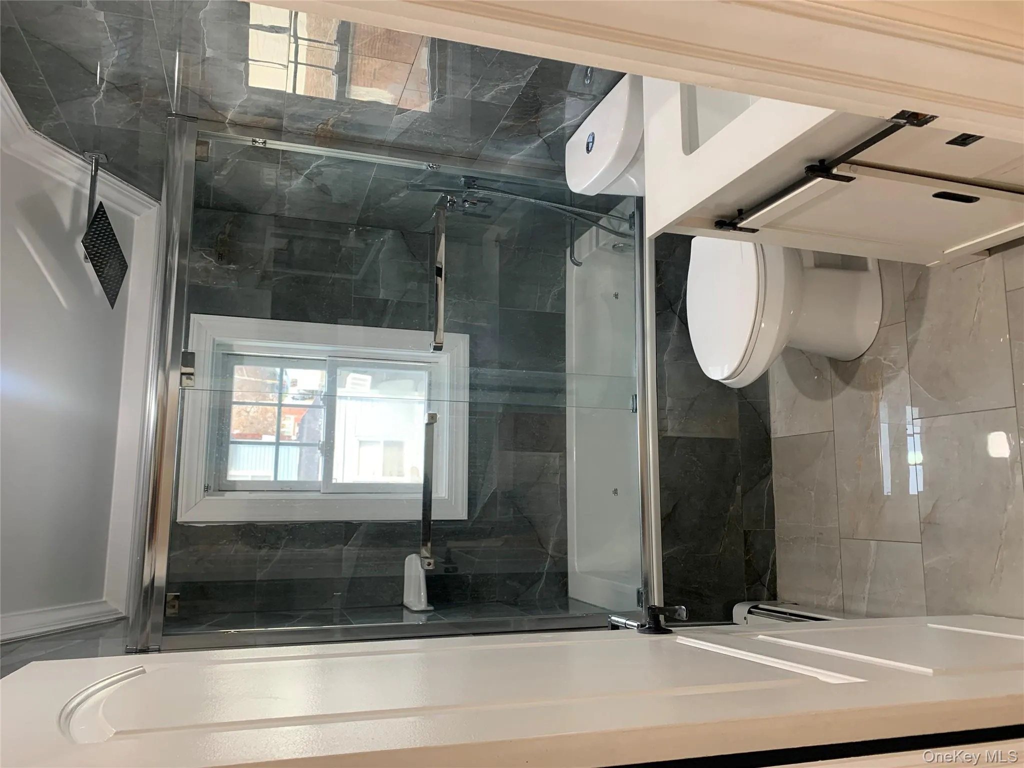 Bathroom with vanity, crown molding, tiled shower / bath combo, and light marble finish flooring Bathroom with vanity, crown molding, tiled shower / bath combo, and light marble finish flooring