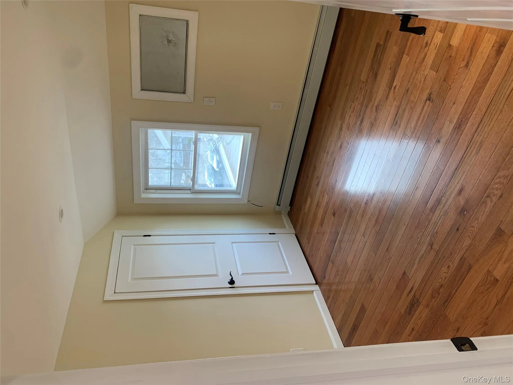 Unfurnished room featuring a baseboard heating unit, lofted ceiling, and hardwood / wood-style flooring Unfurnished room featuring a baseboard heating unit, lofted ceiling, and hardwood / wood-style flooring