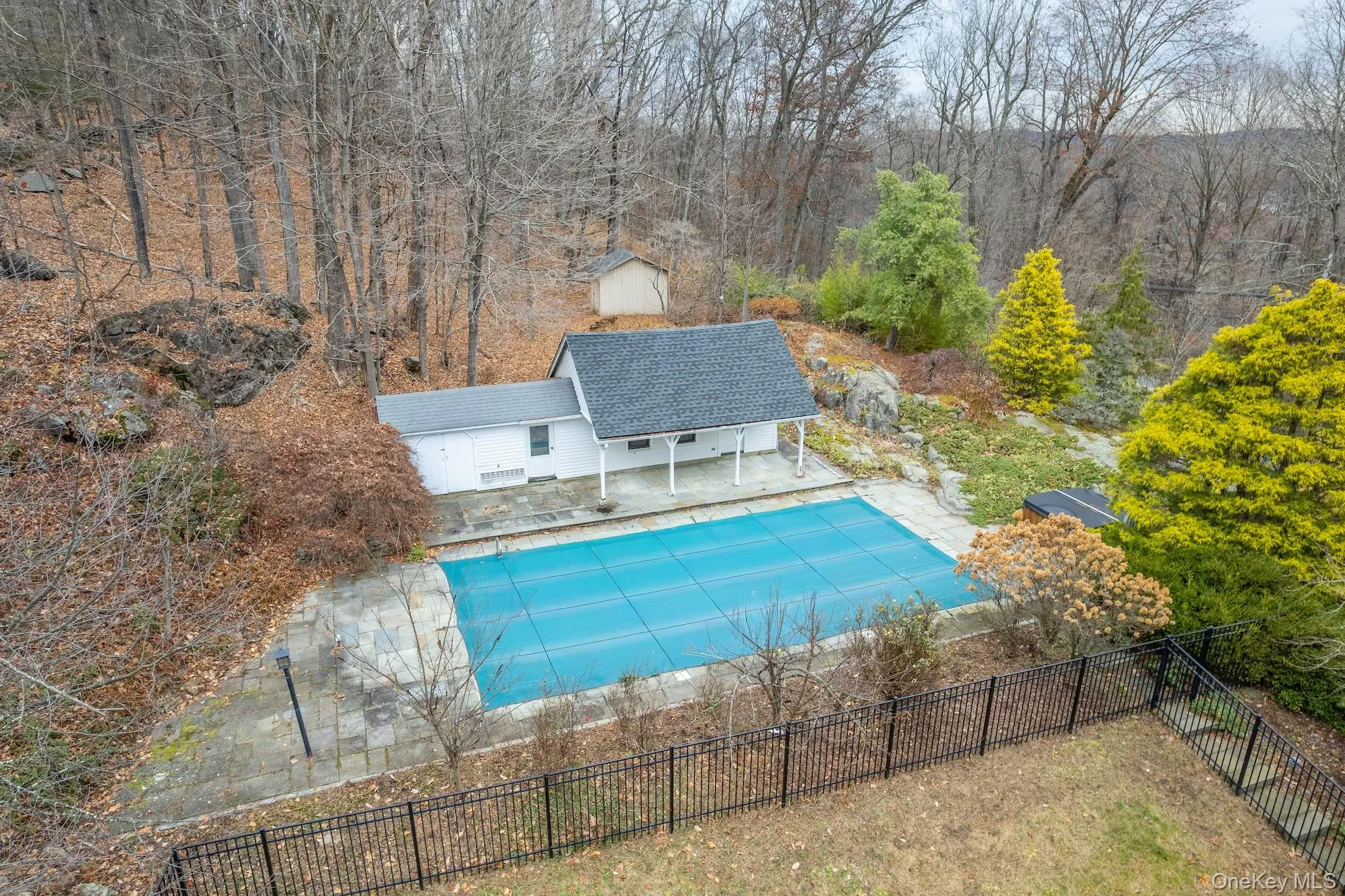 View of pool featuring a patio, a fenced backyard, an outbuilding, and a forest view View of pool featuring a patio, a fenced backyard, an outbuilding, and a forest view