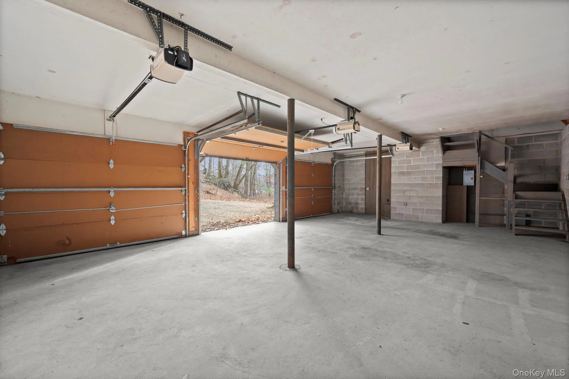 Garage featuring a garage door opener and concrete block wall Garage featuring a garage door opener and concrete block wall