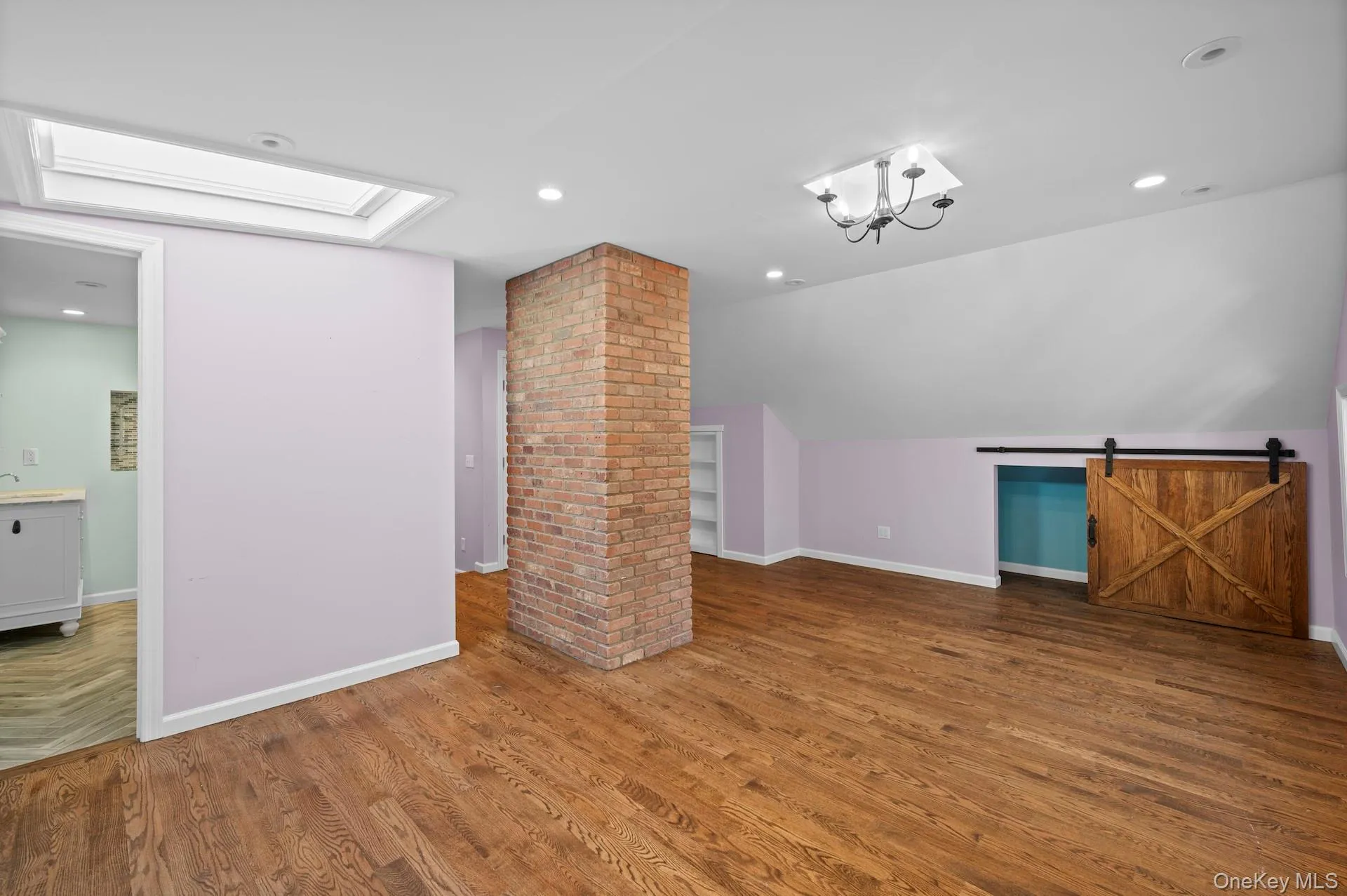 Additional living space featuring wood finished floors, a barn door, vaulted ceiling, recessed lighting, and a chandelier Additional living space featuring wood finished floors, a barn door, vaulted ceiling, recessed lighting, and a chandelier