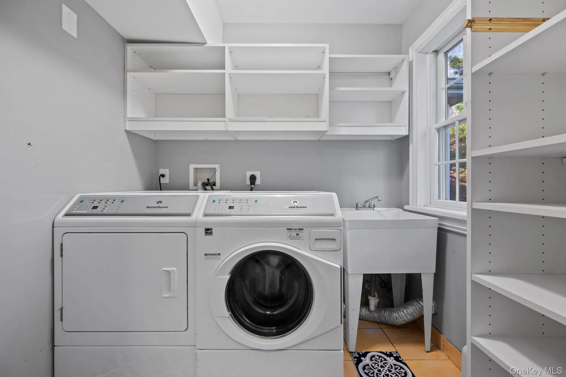 Washroom featuring light tile patterned flooring and washer and dryer Washroom featuring light tile patterned flooring and washer and dryer
