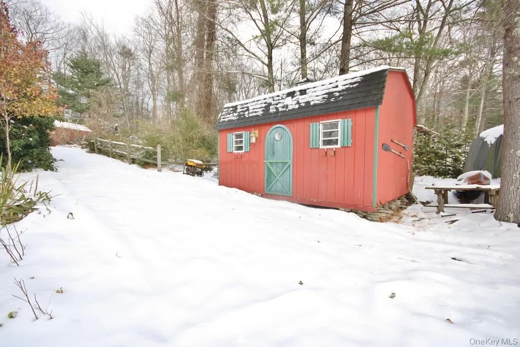 Snow covered structure featuring a storage shed Snow covered structure featuring a storage shed