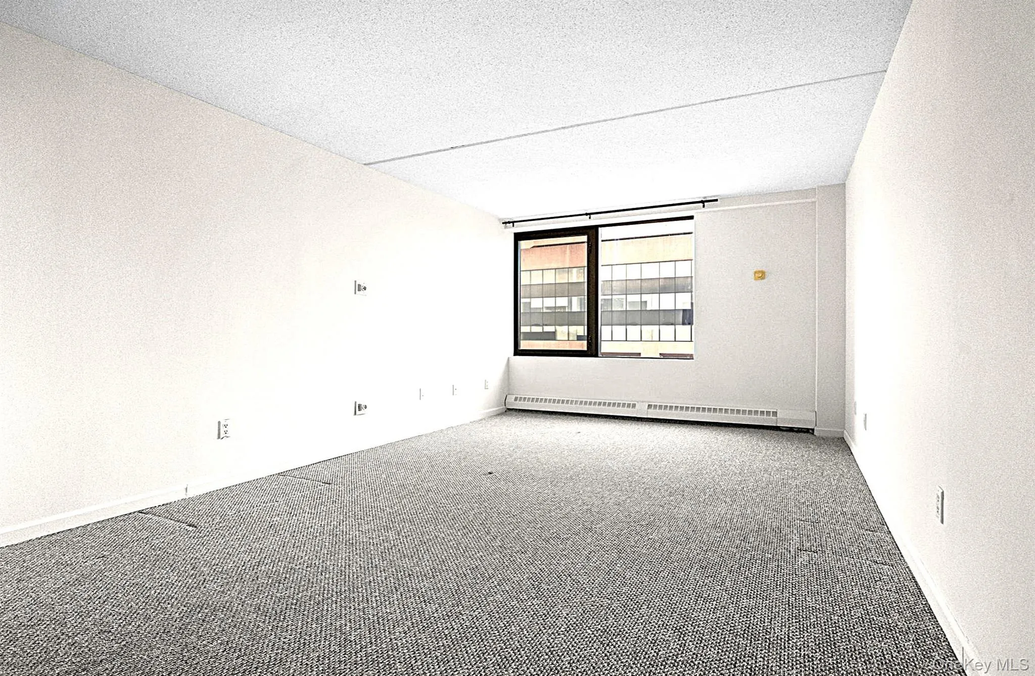 Empty room featuring carpet flooring, a baseboard heating unit, and a textured ceiling Empty room featuring carpet flooring, a baseboard heating unit, and a textured ceiling