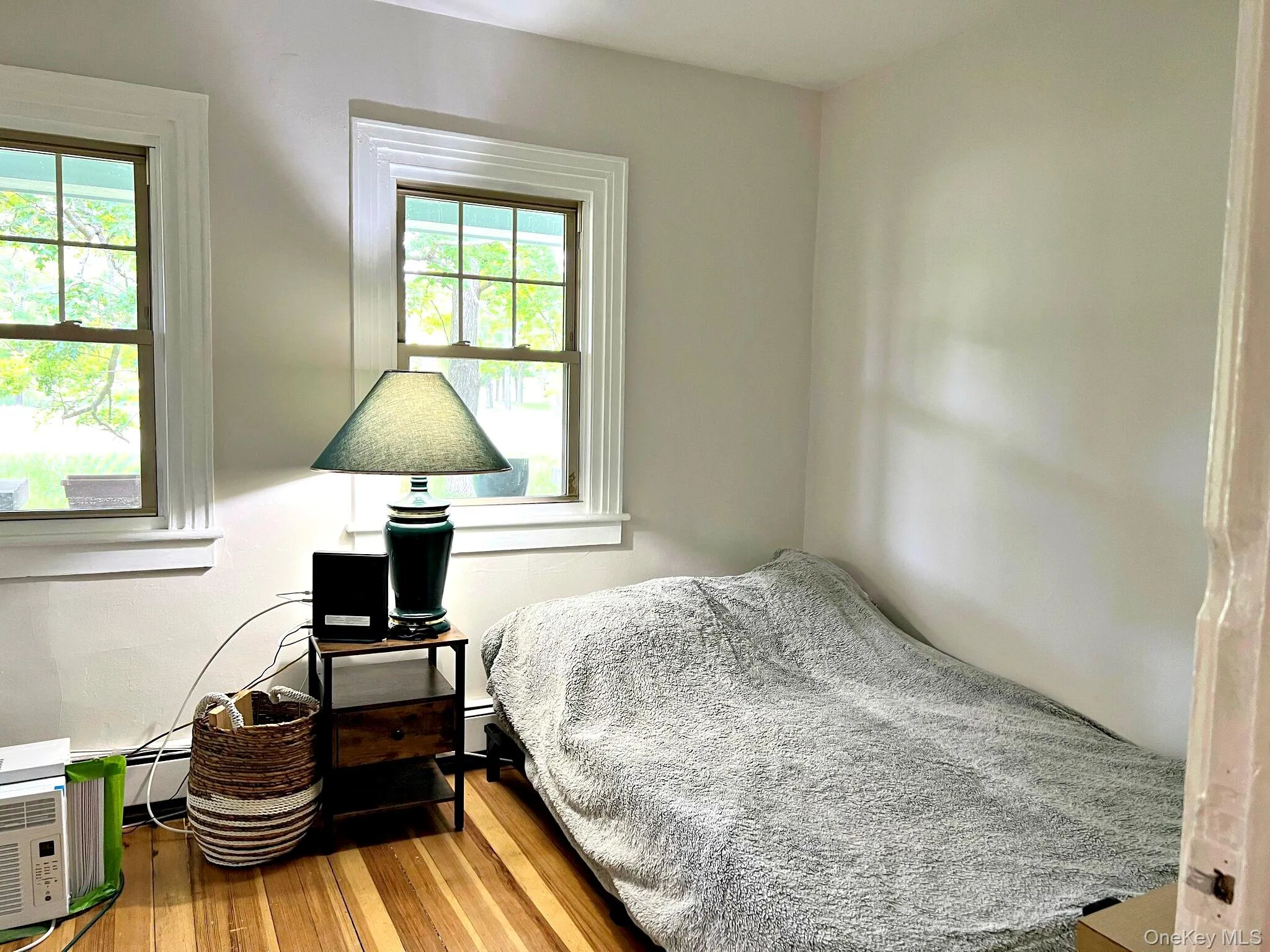 Bedroom with hardwood / wood-style flooring and a baseboard heating unit Bedroom with hardwood / wood-style flooring and a baseboard heating unit