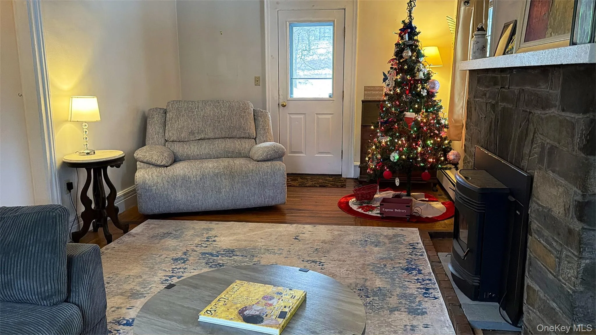 Living area with wood finished floors and a wood stove Living area with wood finished floors and a wood stove