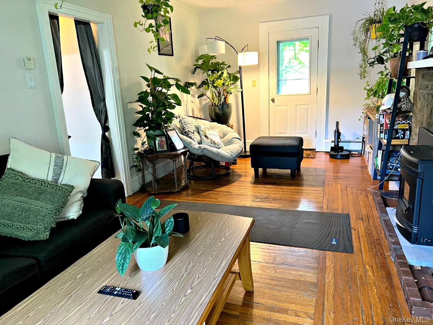 Living area with wood-type flooring, a wood stove, and ornamental molding Living area with wood-type flooring, a wood stove, and ornamental molding