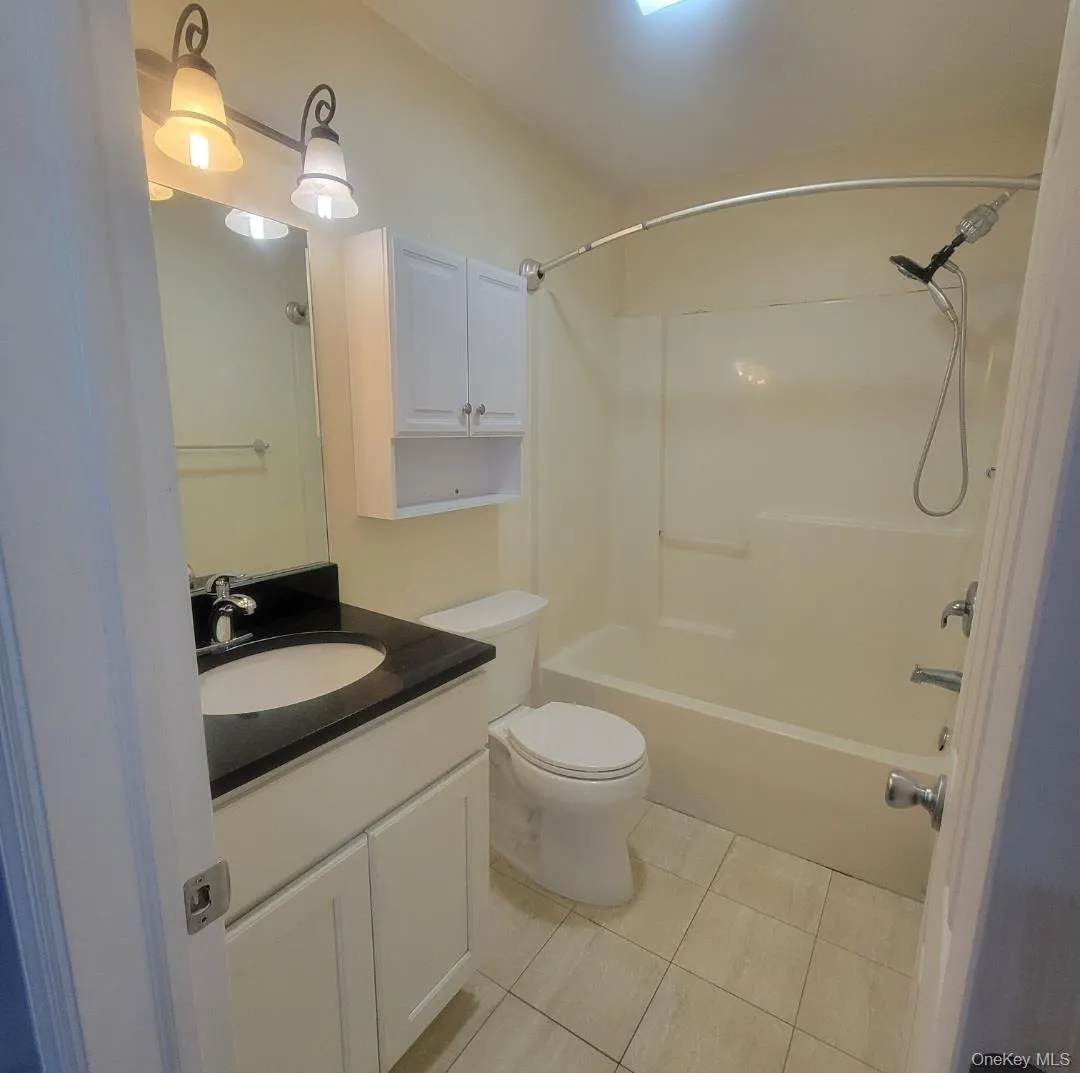 Full bathroom with vanity, shower / bathtub combination, and light tile patterned flooring Full bathroom with vanity, shower / bathtub combination, and light tile patterned flooring