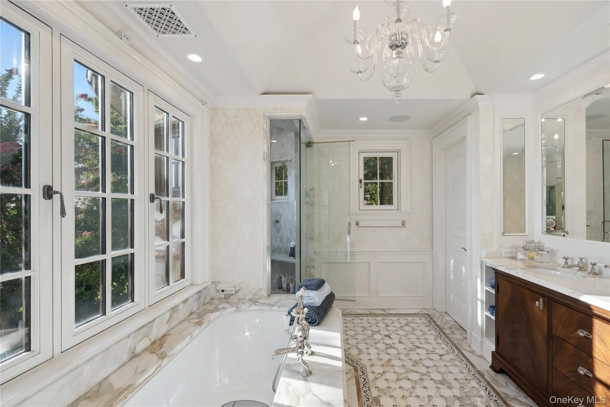 Full bathroom with a garden tub, vanity, lofted ceiling, crown molding, and a chandelier Full bathroom with a garden tub, vanity, lofted ceiling, crown molding, and a chandelier