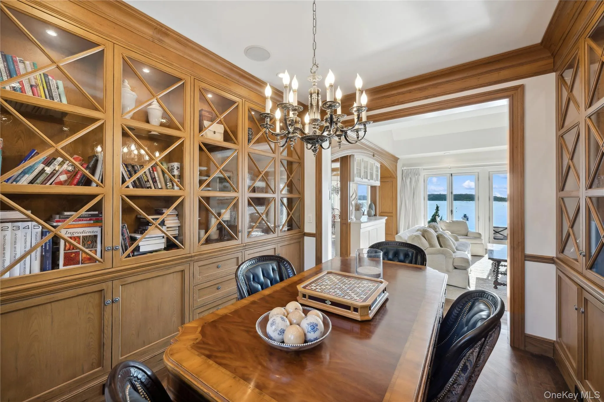Dining space with a chandelier, arched walkways, a water view, and dark wood-type flooring Dining space with a chandelier, arched walkways, a water view, and dark wood-type flooring