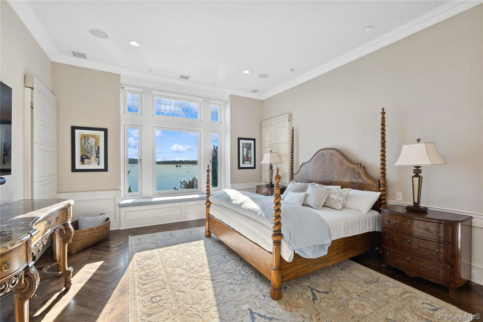 Bedroom with a wainscoted wall, ornamental molding, a water view, a decorative wall, and recessed lighting Bedroom with a wainscoted wall, ornamental molding, a water view, a decorative wall, and recessed lighting